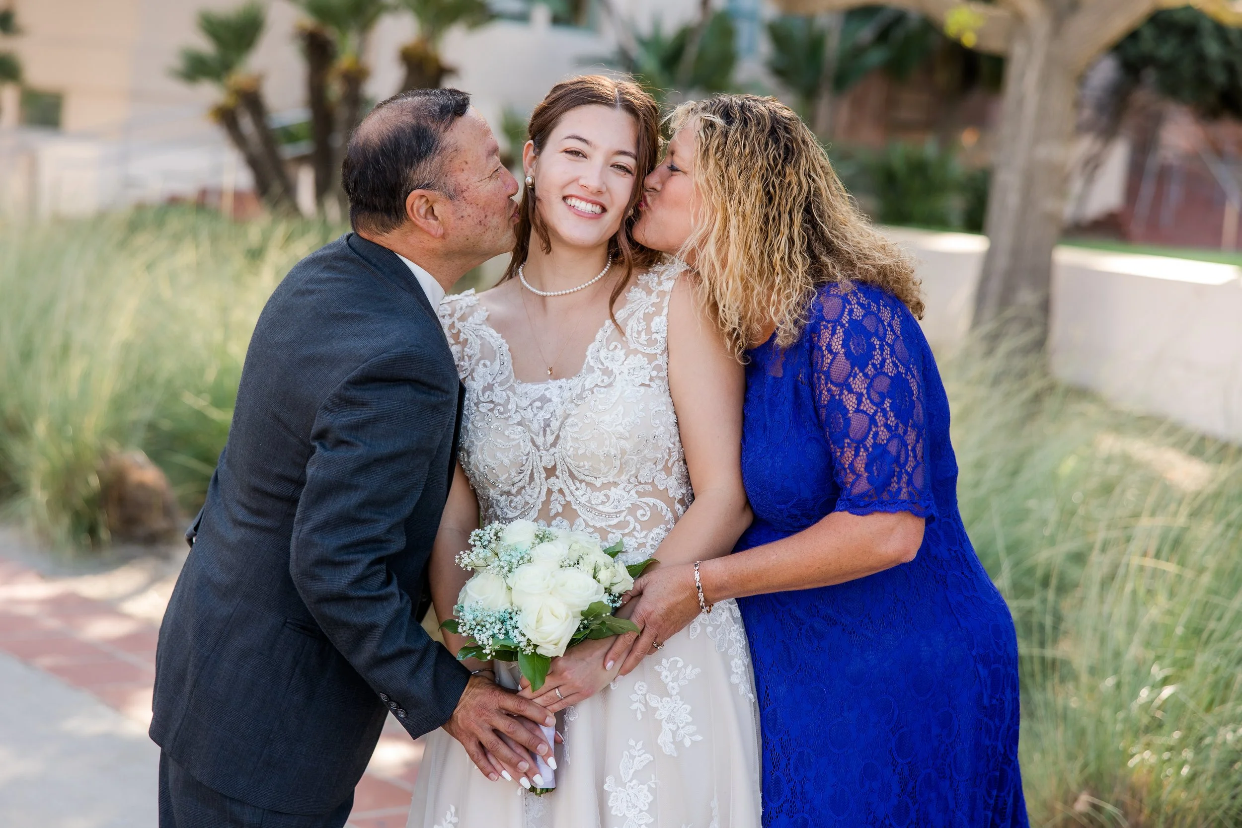 parents kissing bride