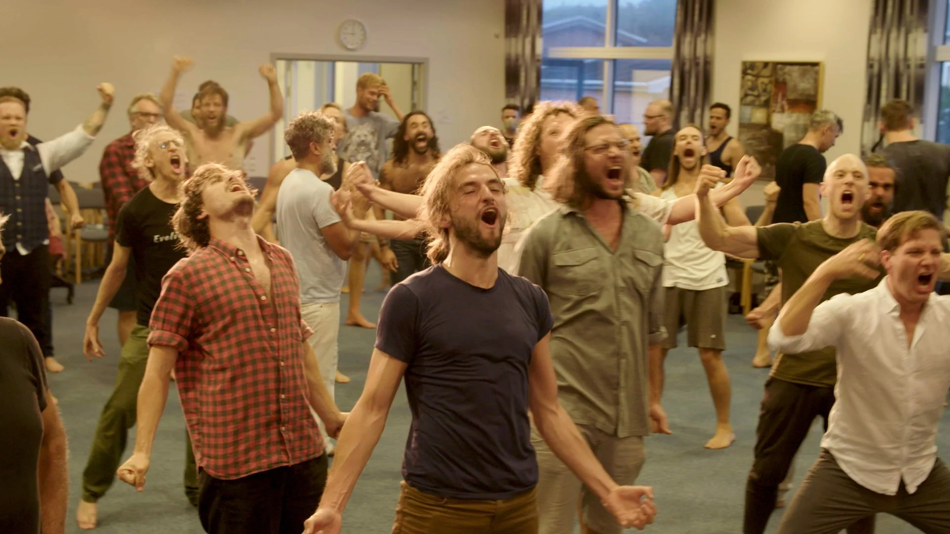 Men shouting together during a group exercise, a still from Confessions of a Swedish Man