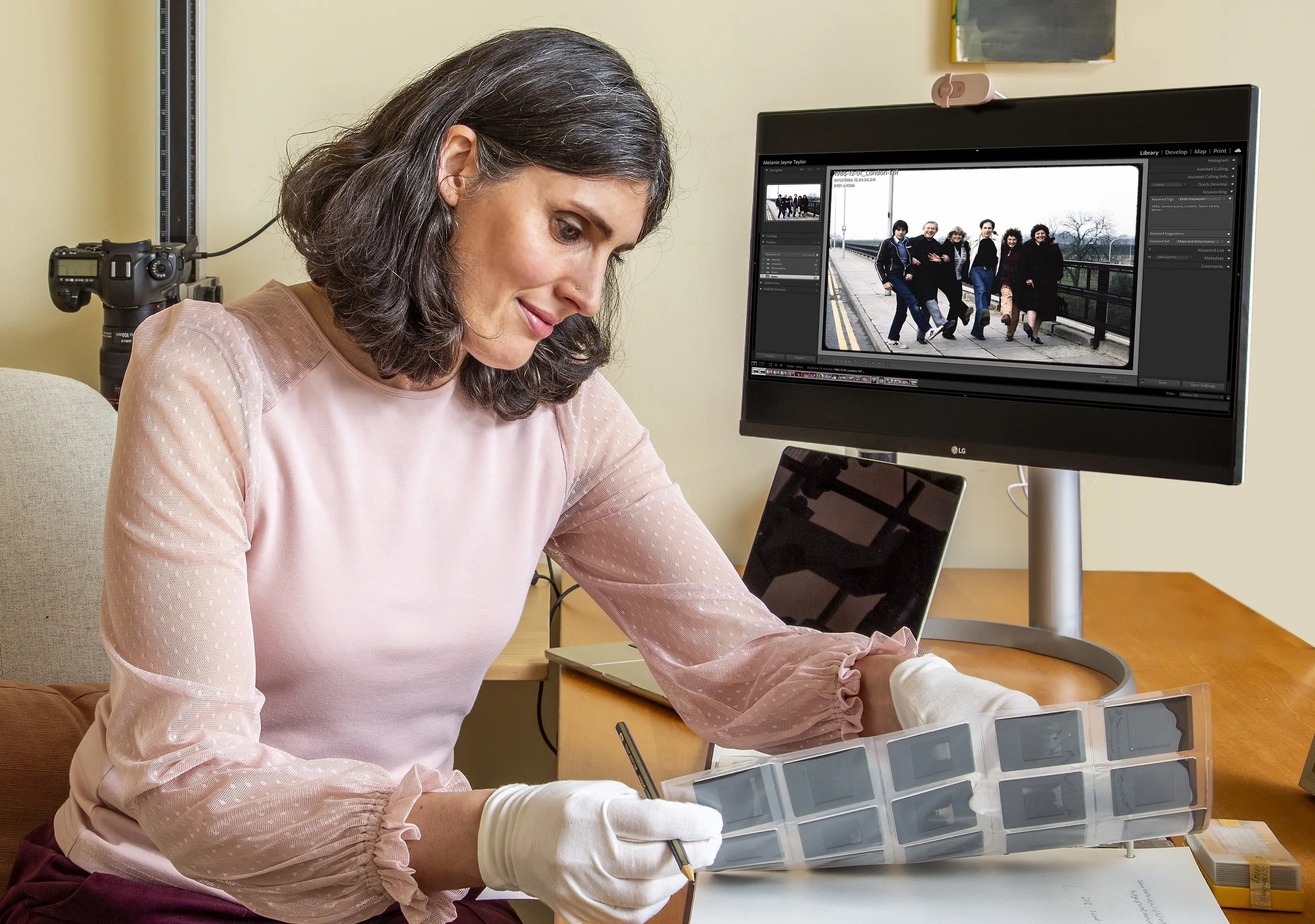 Melanie digitising 35mm slides using a camera scanning setup, with the scanned slide image displayed on the computer screen.