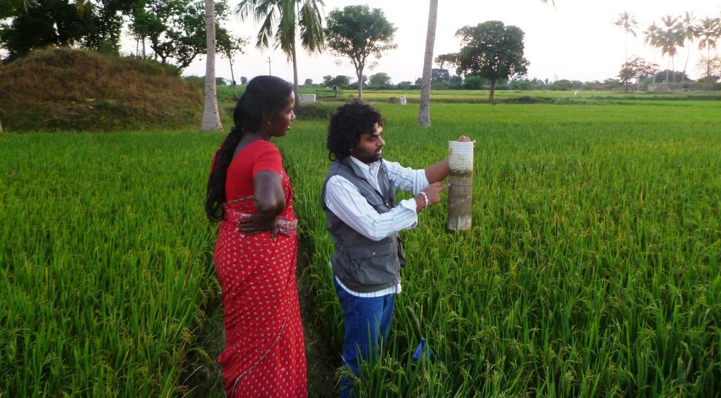 Sumathi and Rakesh looking at a field water tube installed in a field location