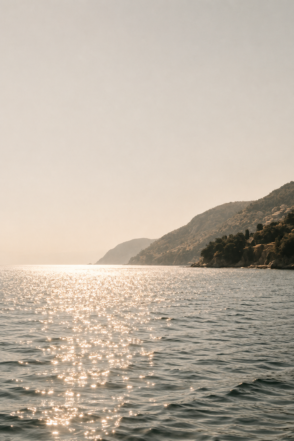 Sunlit Mediterranean sea and coastline illustrating how every element of luxury branding works together to create a cohesive feeling.