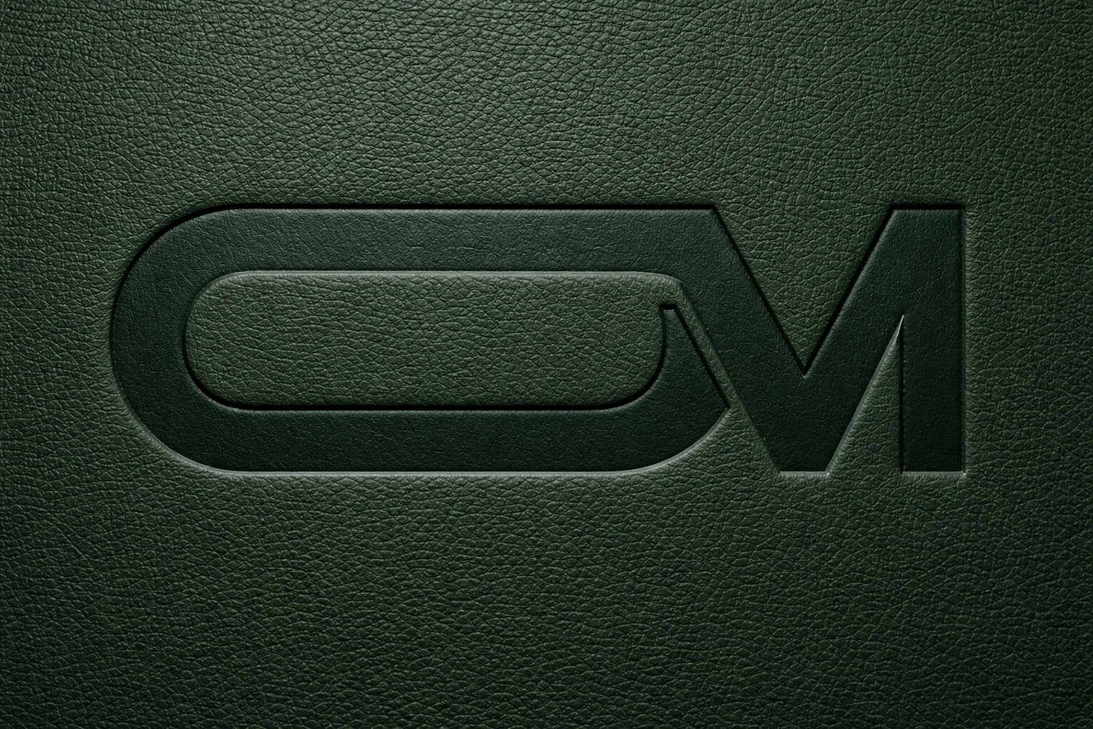 Olive Mercy OM submark logo embossed into dark green leather texture.