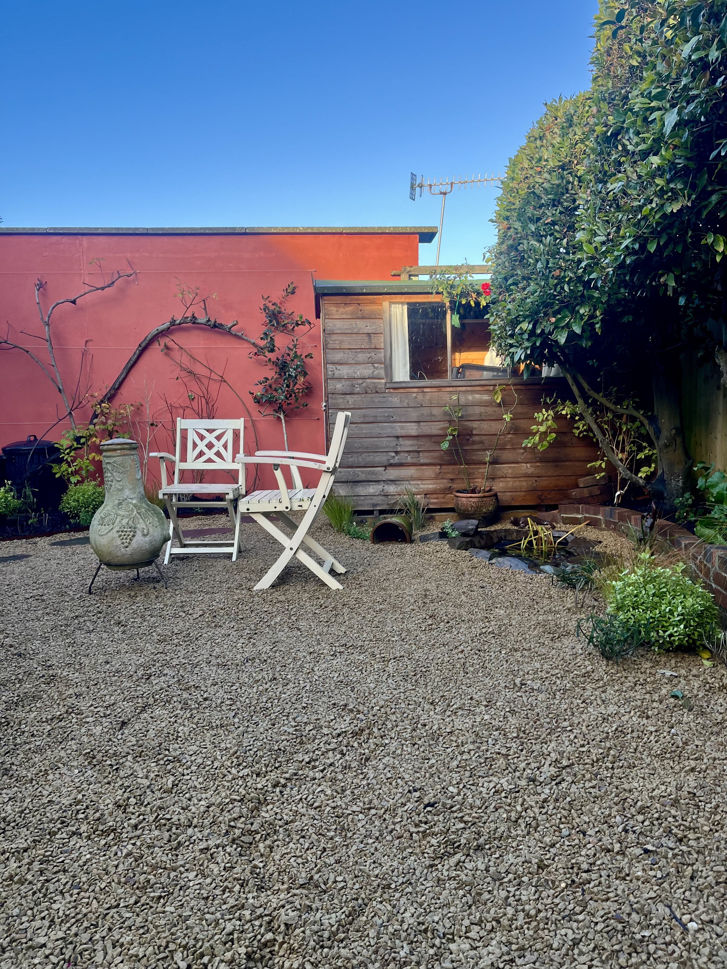 Low area of garden in Saltdean, Brighton & Hove, Sussex showing the rewired Rose and the pond with a small seating area