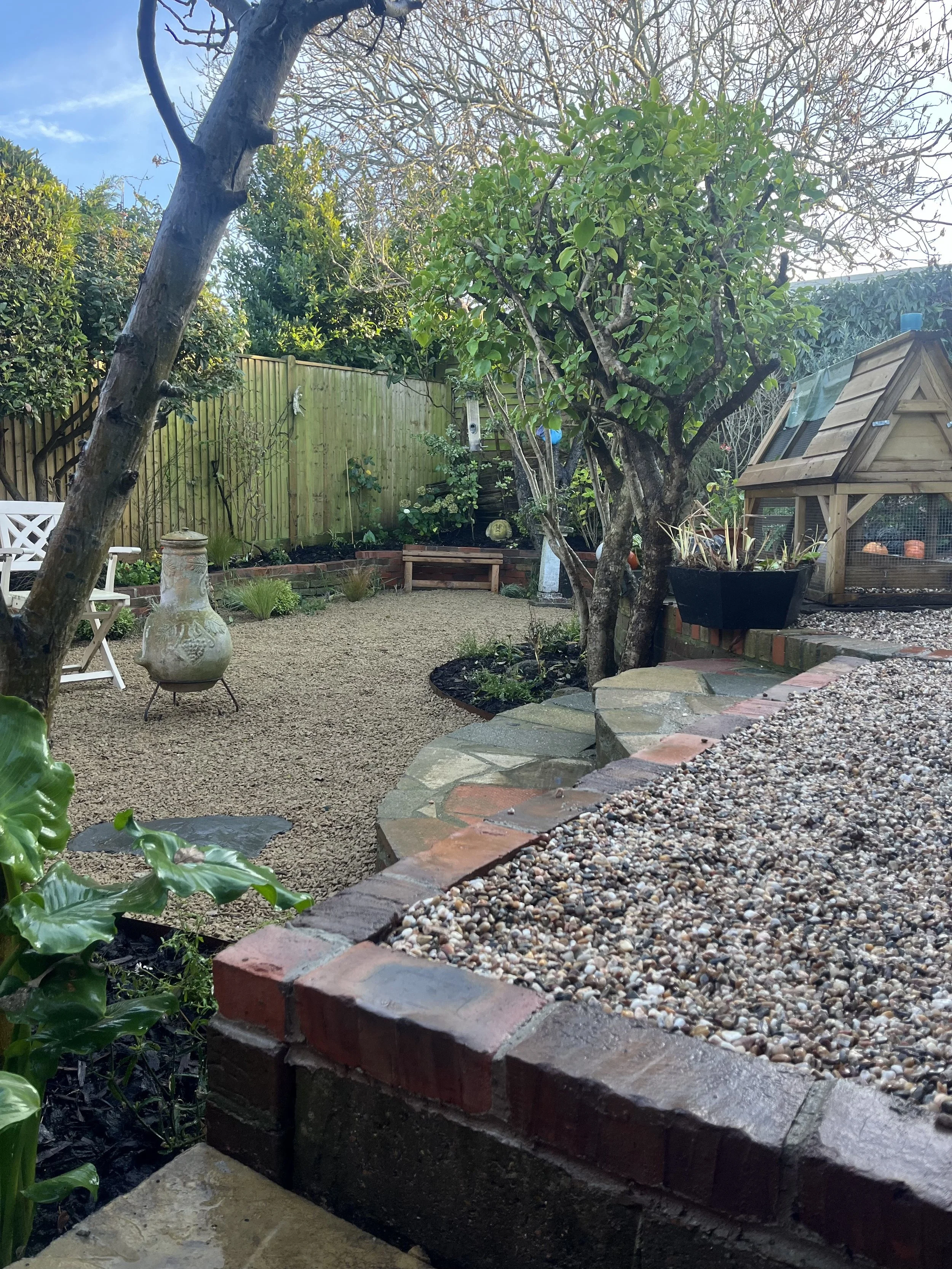 Low-angle picture of the garden in Saltdean, Brighton & Hove, Sussex. Showing the brick work and shingle work that was done by Green Boys Garden Design
