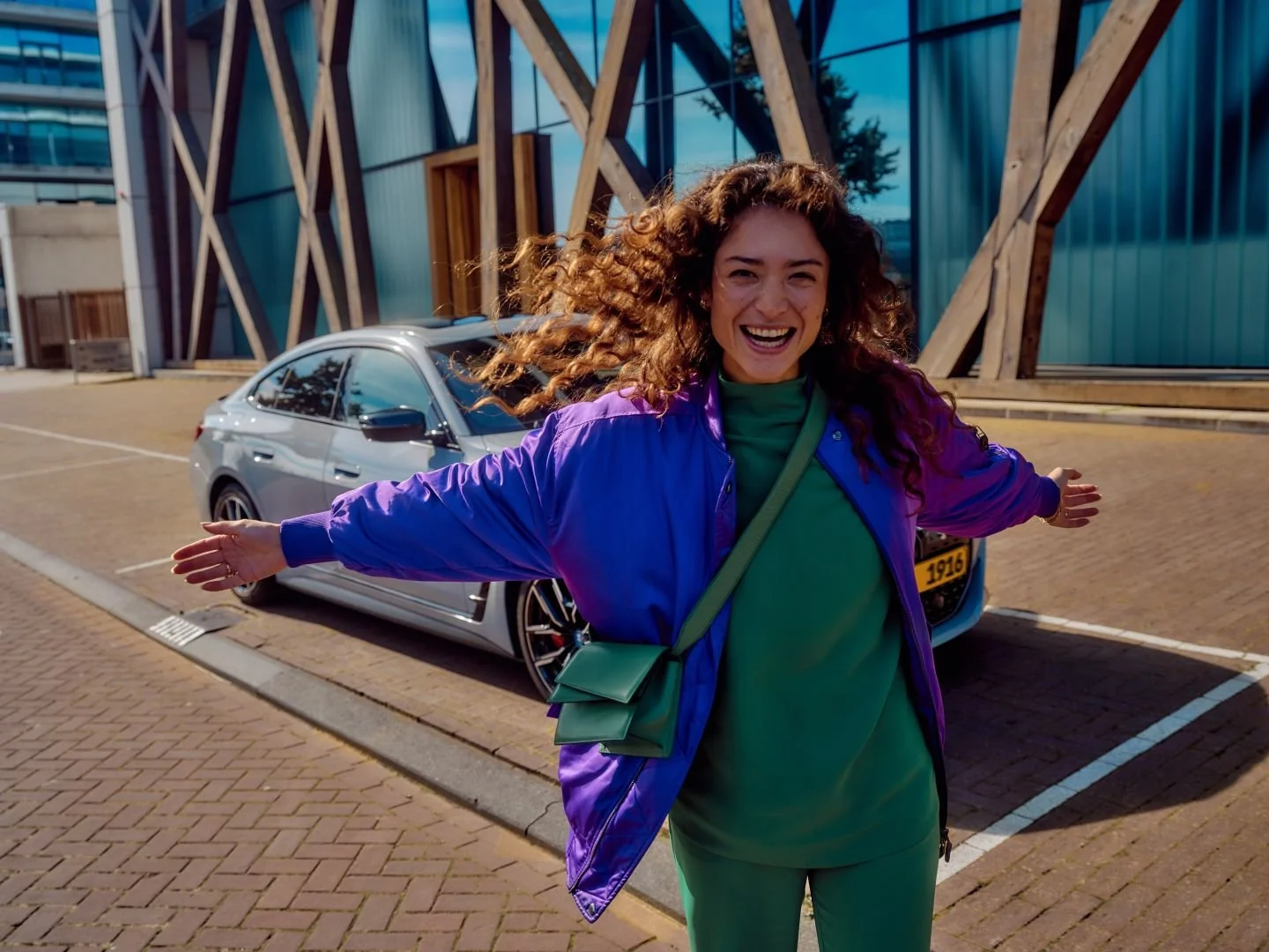 Joyful woman next to her car in the city, Athlon Car Lease shoot in Amsterdam