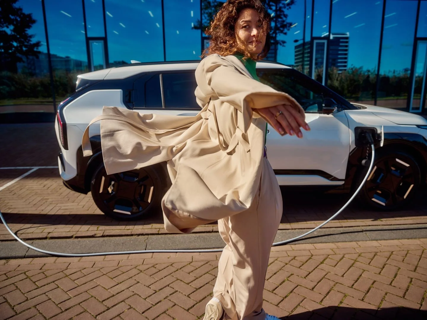 Woman at a public charging station on a windy day, Athlon Car Lease shoot in Amsterdam