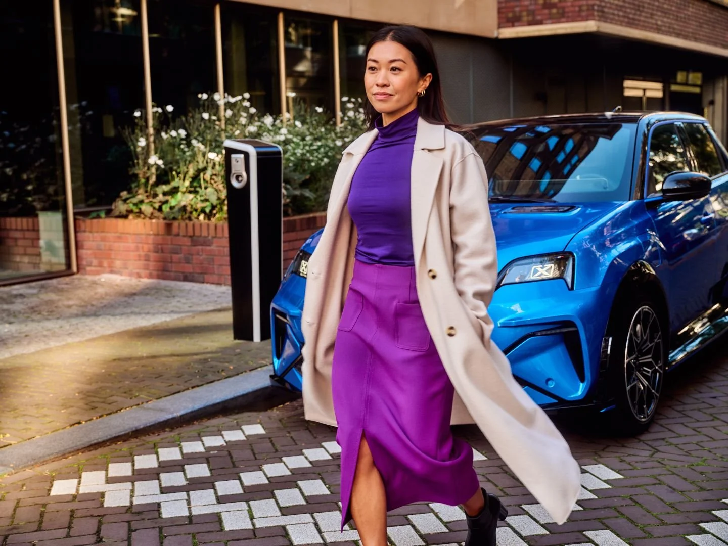 Woman walking away from her charging car, Athlon Car Lease shoot in Amsterdam