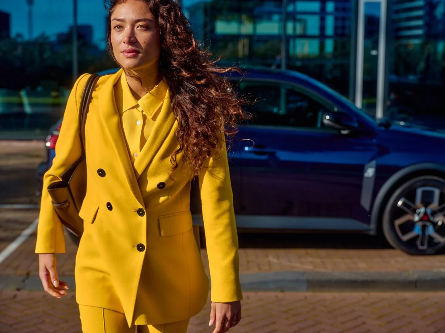 Woman walking away from her parked car in the city, Athlon Car Lease shoot in Amsterdam