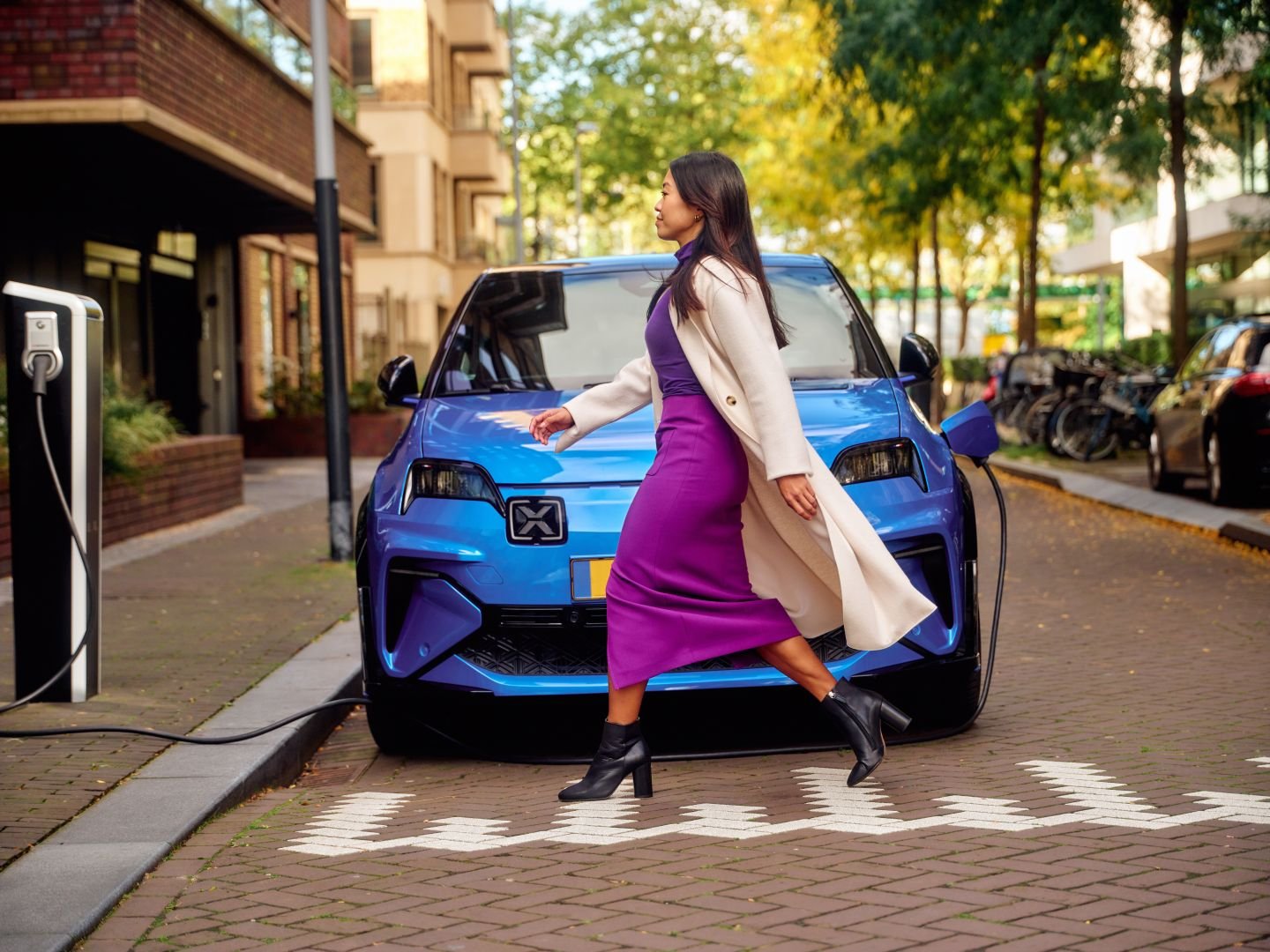Woman walking towards a public charger, Athlon Car Lease shoot in Amsterdam