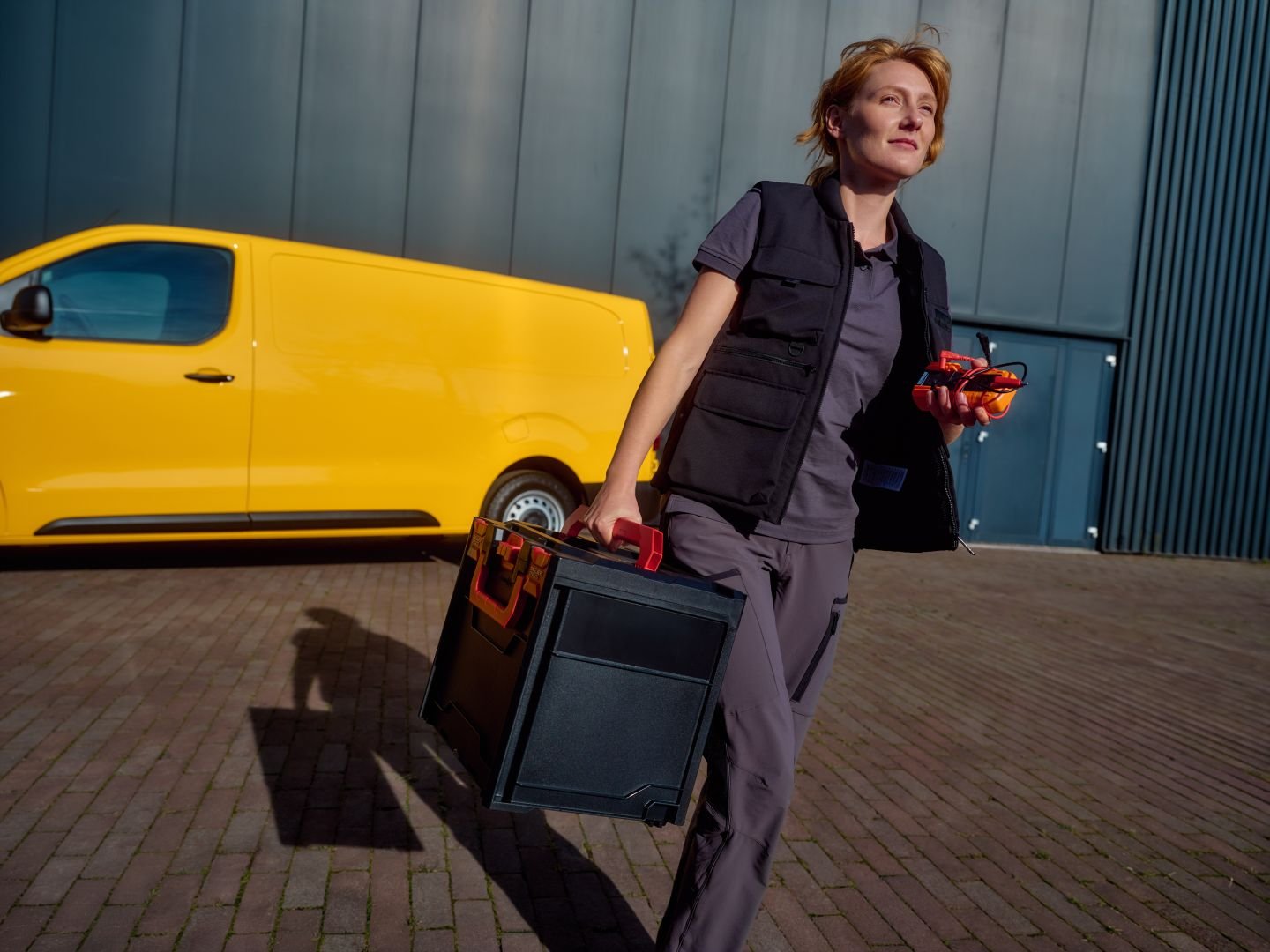 Female technician walking away from her van, Athlon Car Lease shoot in Amsterdam