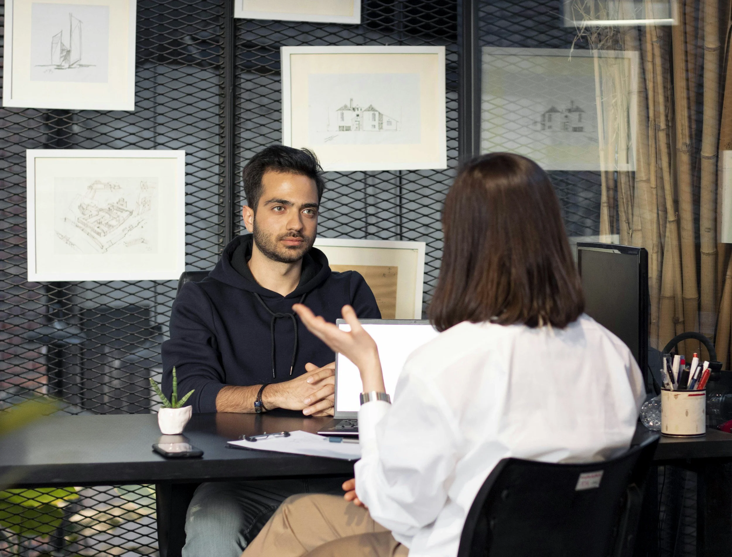 Two architects at a meeting, discussing salary expectations for a new hire.