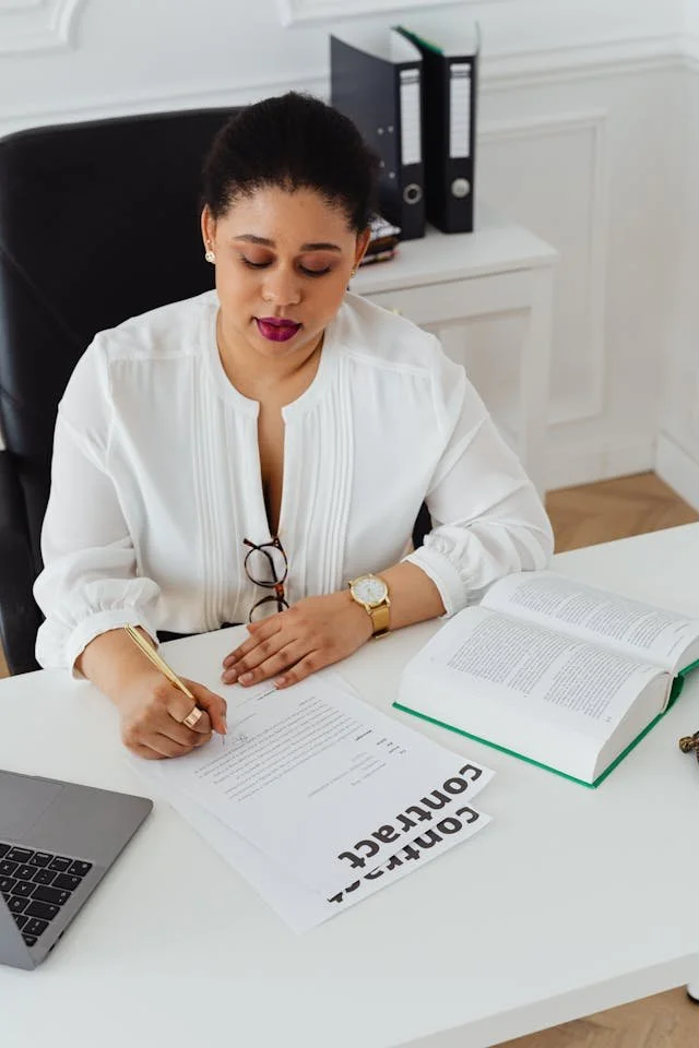 A portrait of a woman legal professional working at a desk.