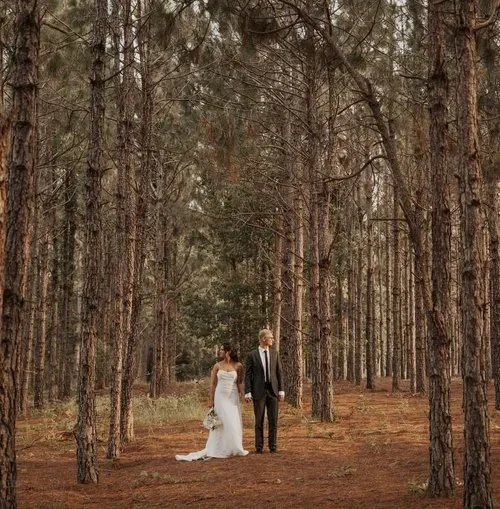Couple standing in tall pine forest at outdoor wedding venue near Cocoa Beach Florida