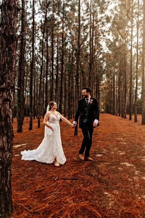 Couple walking through pine forest at outdoor wedding venue near Plant City Florida at The Pinery