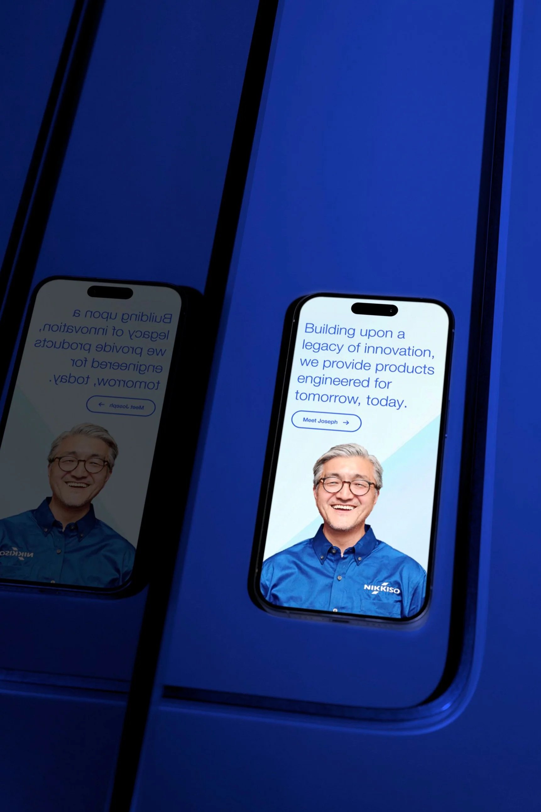 Smartphone with a smiling man in a blue shirt on the screen, displayed on a blue surface.