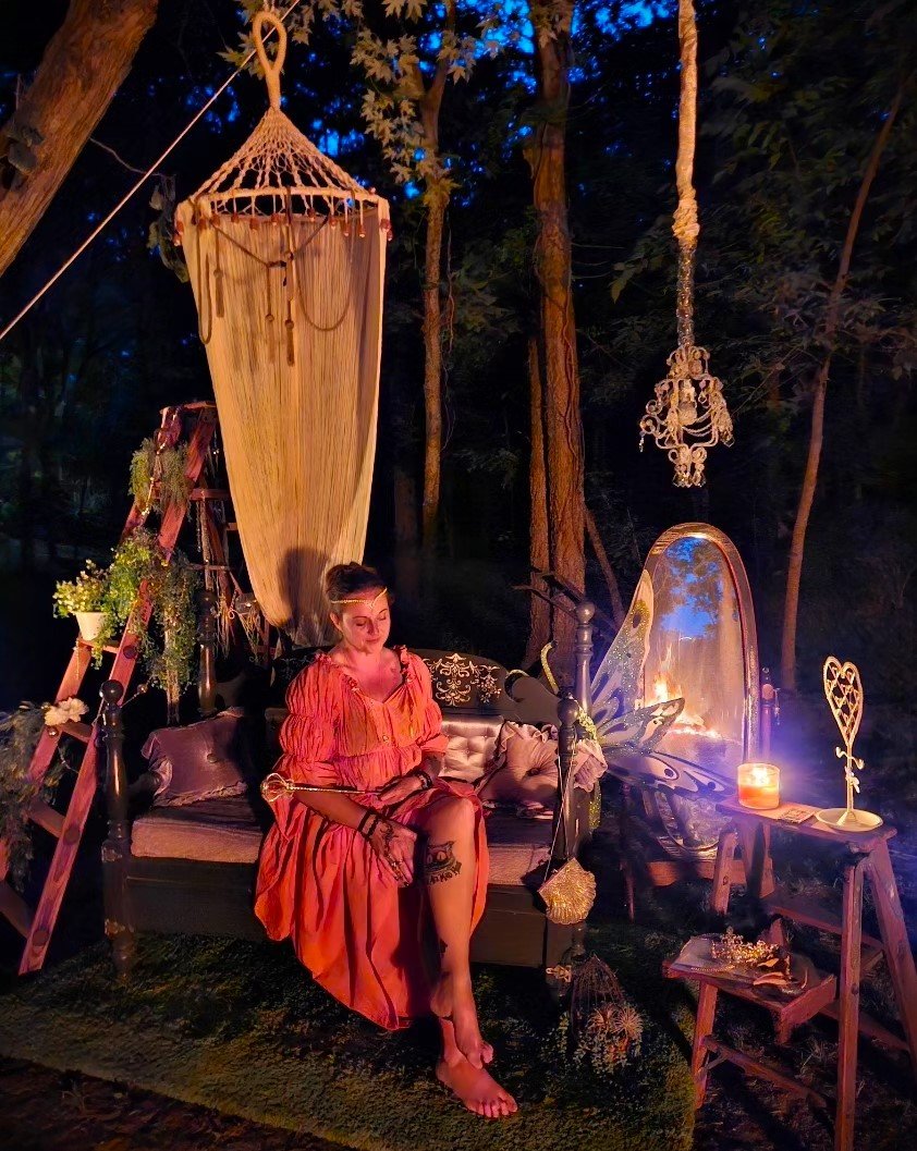 Woman in red dress meditating outdoors at Enchanted Forest Treehouse retreat
