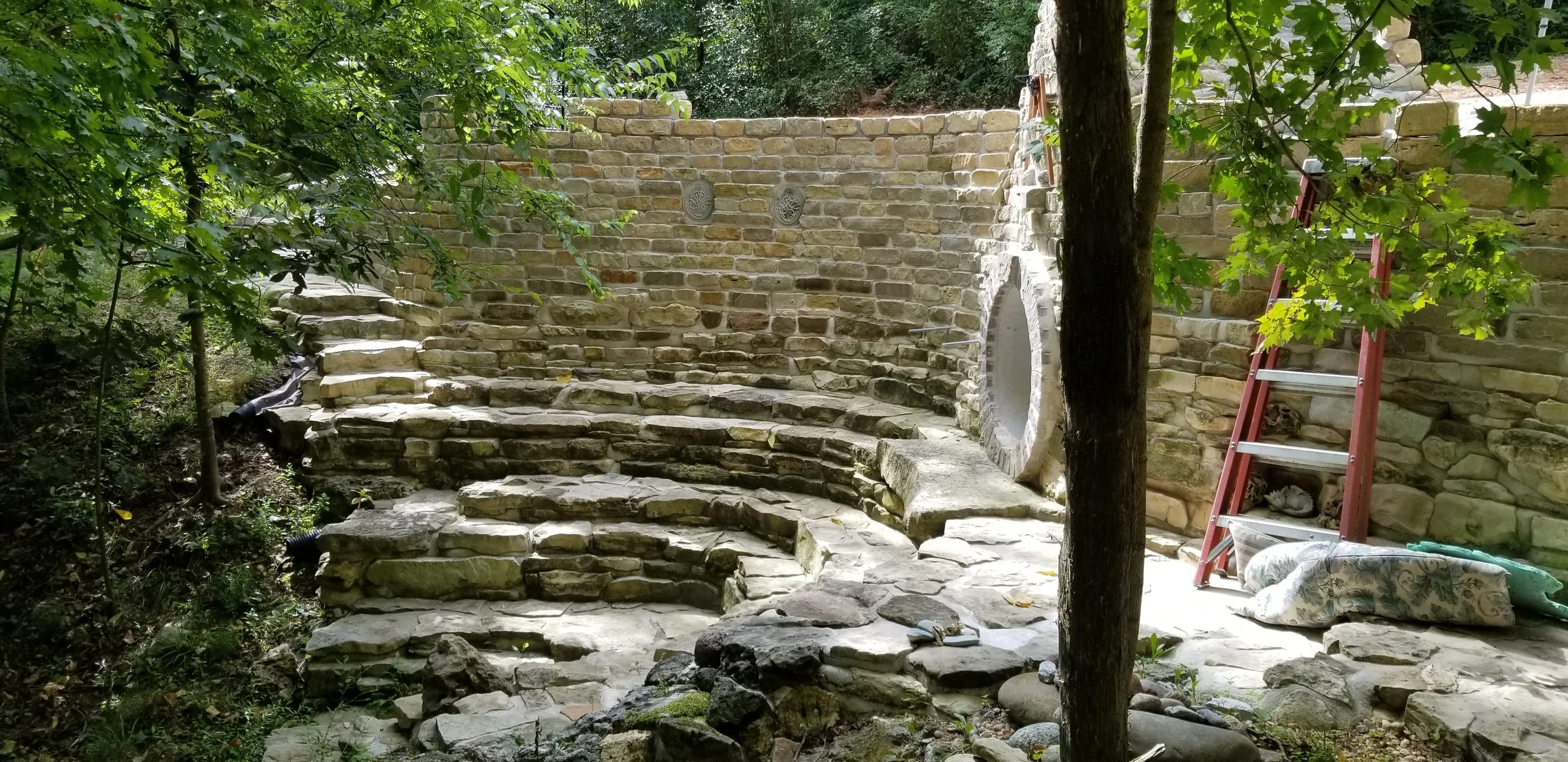 Stone wall with hobbit door at Enchanted Forest Treehouse gardens