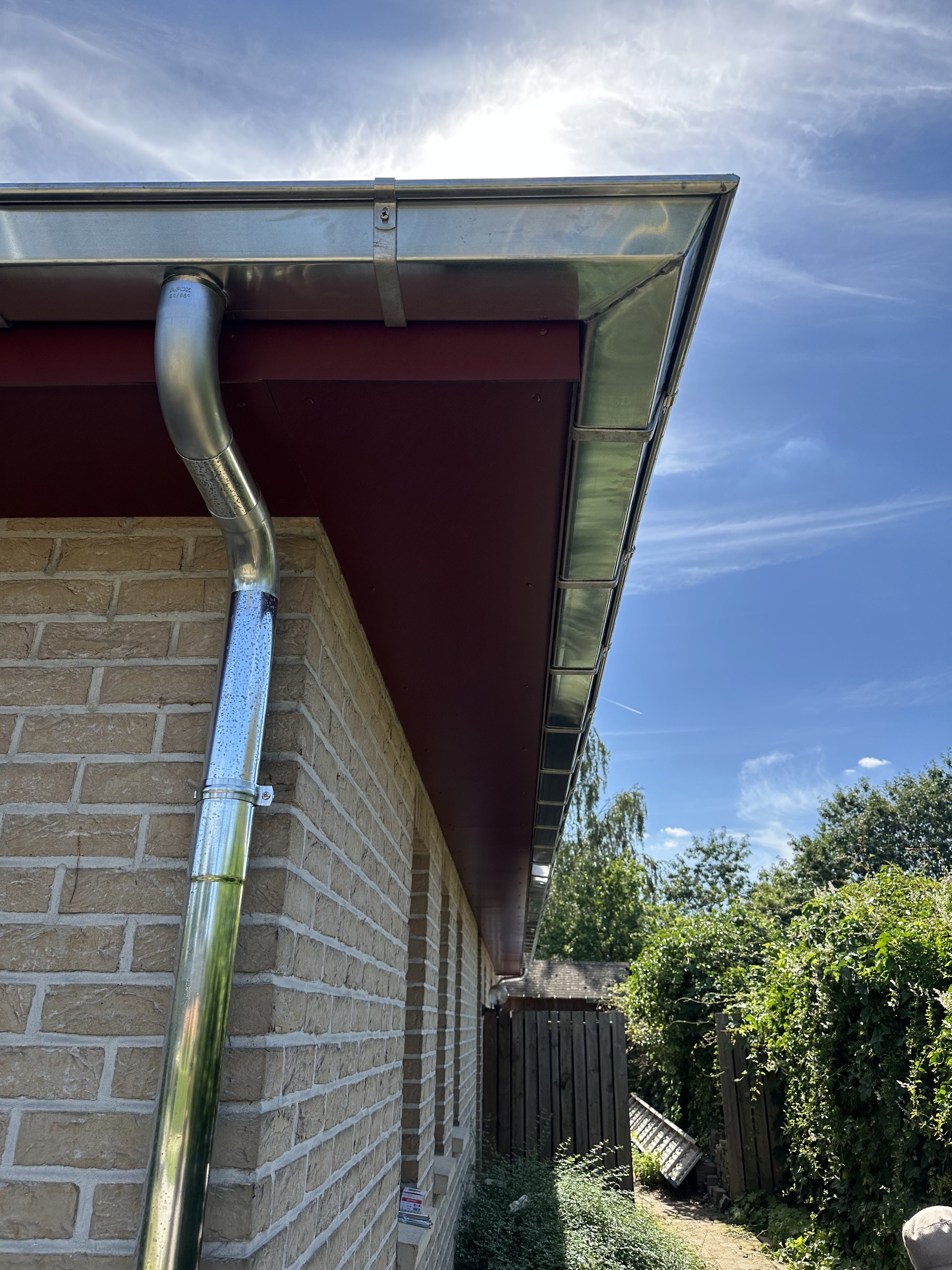 Werken aan  dakgoot en regenpijp voor het dak van een woning in Geel.
