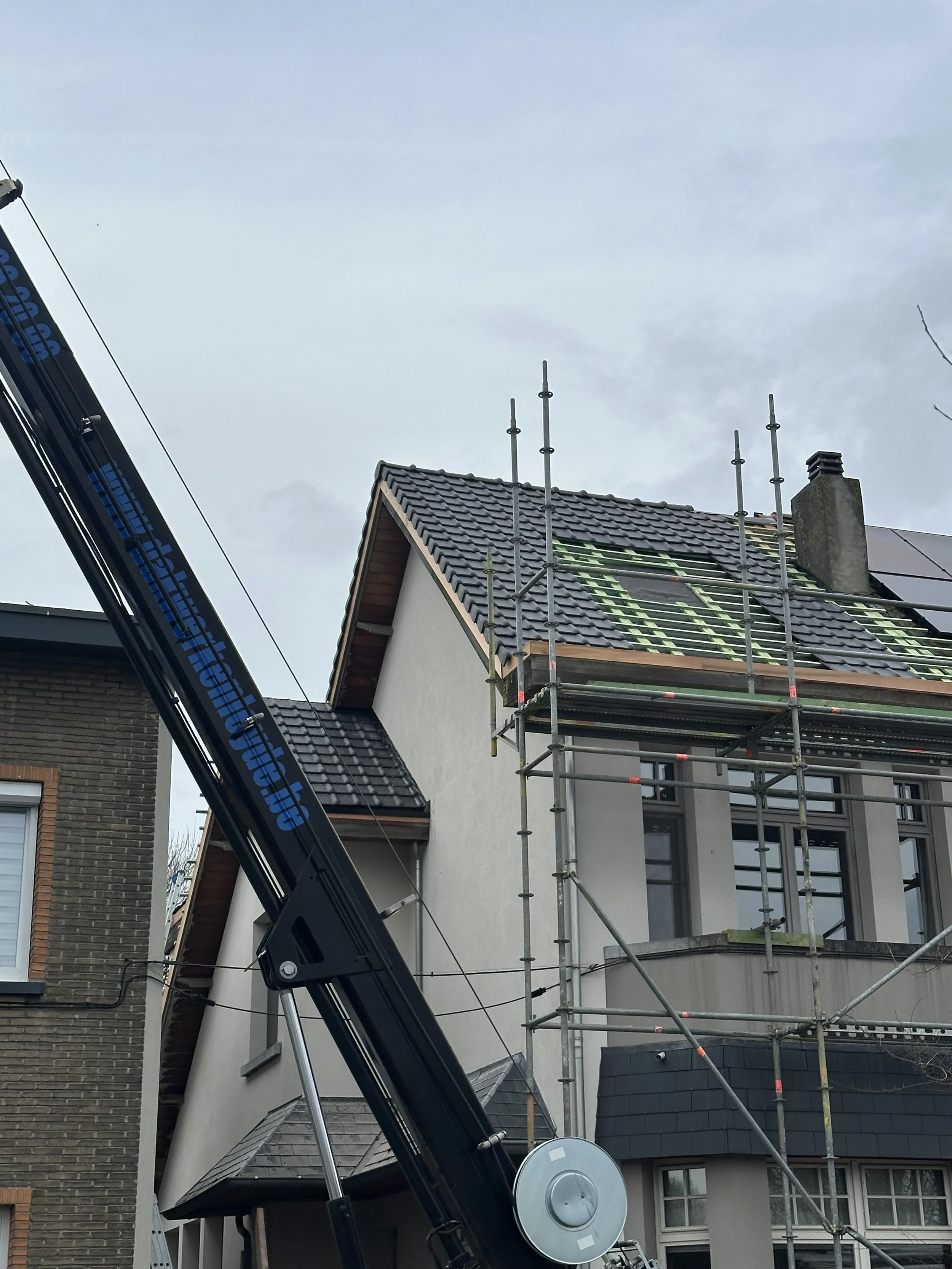 Een huis onder constructie met steigers en een deel van het dak in aanbouw in Geel.