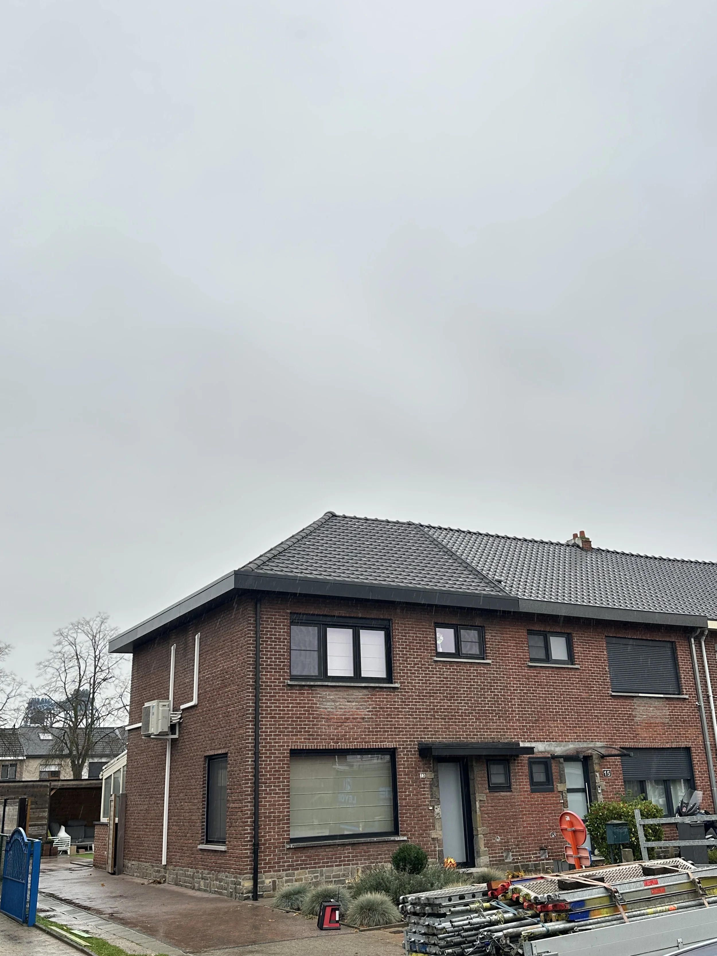 Dakwerken aan een huis met een pannendak en meerdere ramen in Geel.