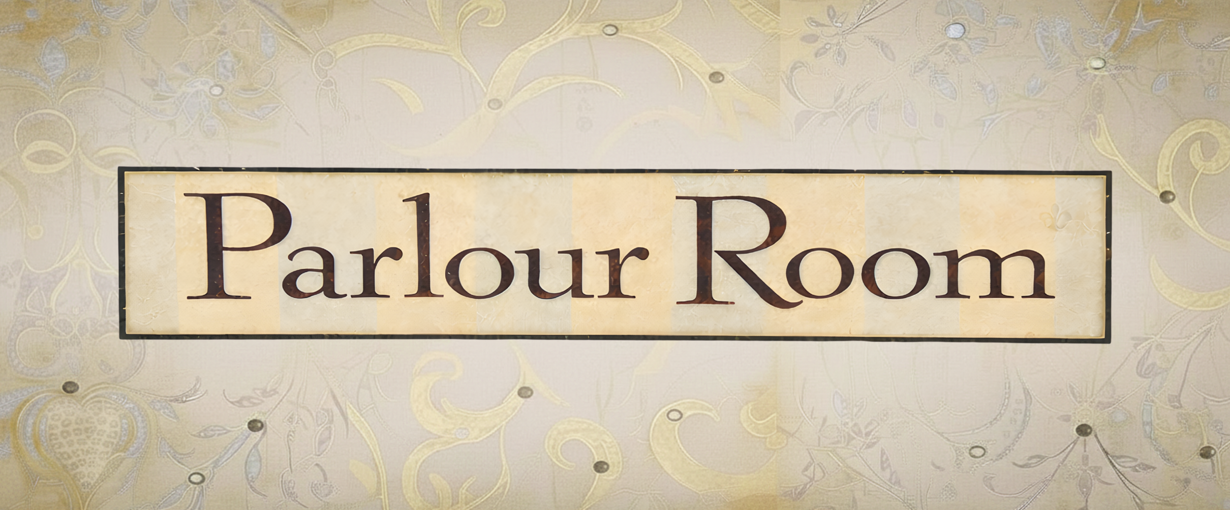 A sign with the words 'Parlour Room' on it, mounted on a wall with decorative wallpaper.