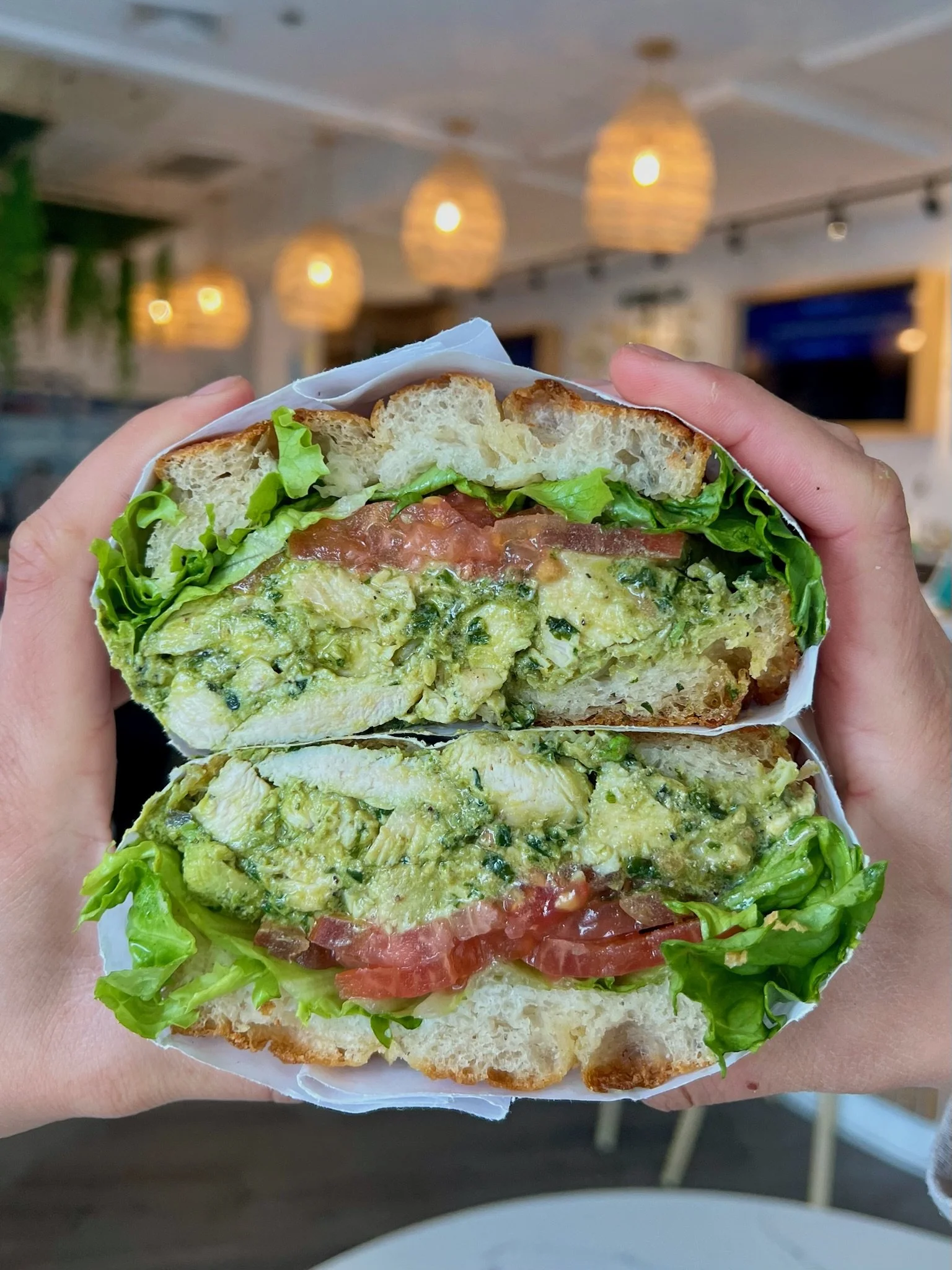 PESTO SARRAD chicken, whipped ricotta pesto, sun-dried tomatoes, pickles, little leaf lettuce on Fresh focaccia