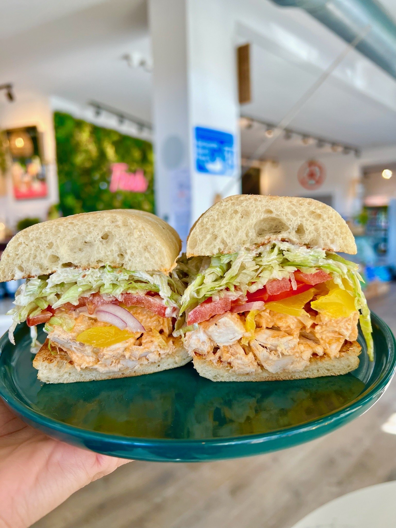 MOTHER CLUCKER buffalo chicken salad, shredded iceberg lettuce, red onion, banana peppers, tomato, bleu cheese dressing on warm ciabatta