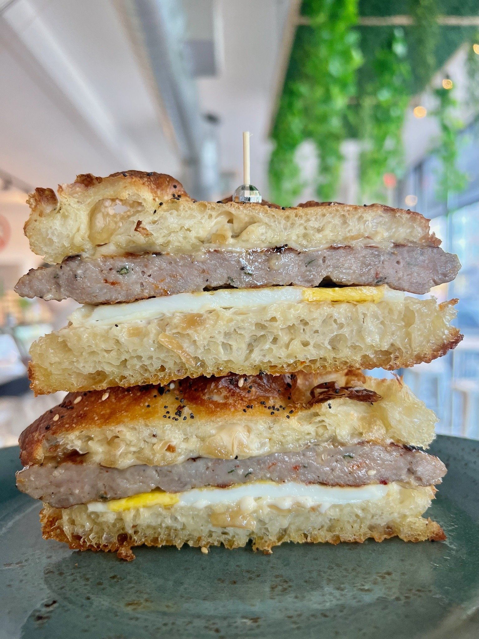 SEXY SAUSAGE BOY house breakfast sausage, fried egg, bourbon maple caramelized onion aioli, cheddar cheese on everything focaccia