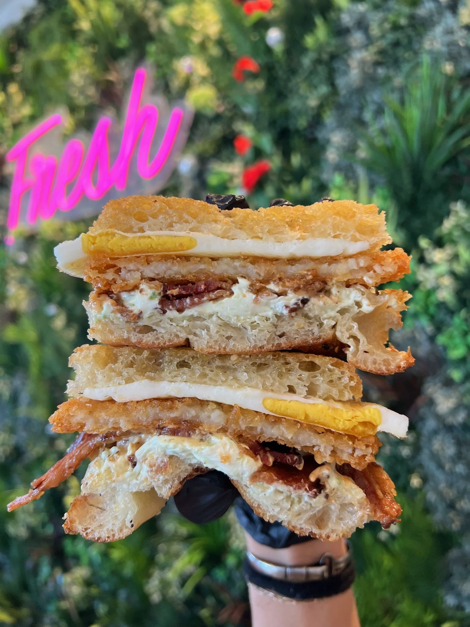 WAKE N' BACON SANDWICH  fried egg, applewood bacon, jalapeno cream cheese, hash brown, sriracha aioli on Fresh's everything focaccia 