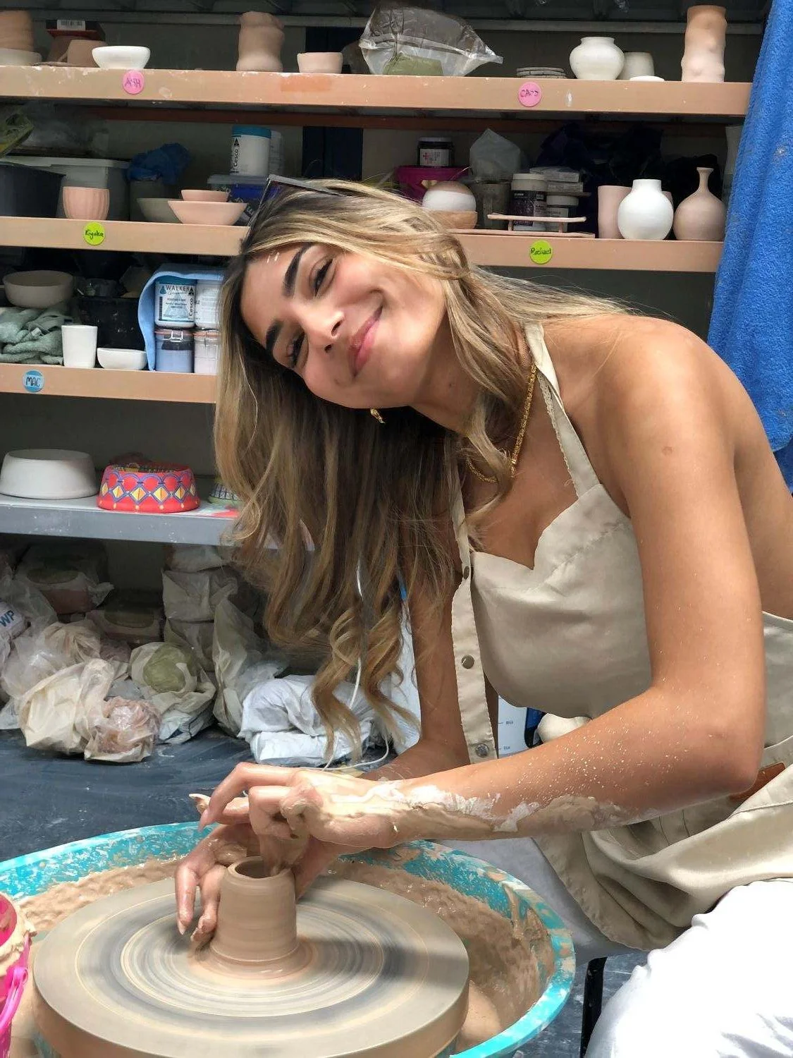 Smiling student learning pottery wheel throwing at a beginners clay workshop at Kingston Clay Studio in South East Melbourne.