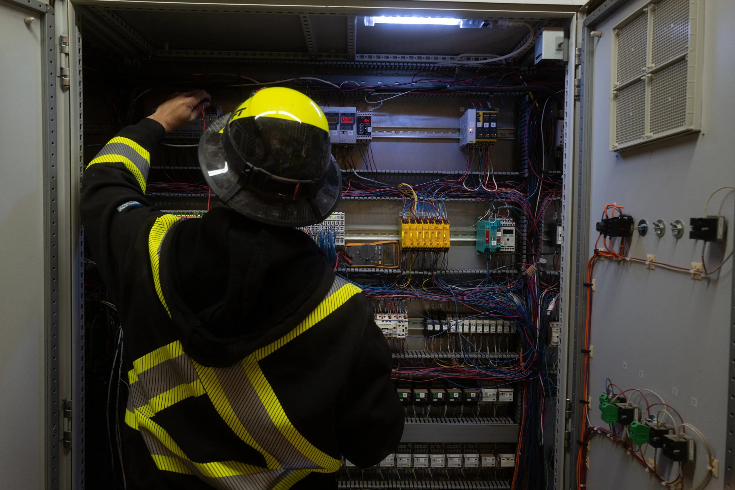 Electrician working inside a service panel