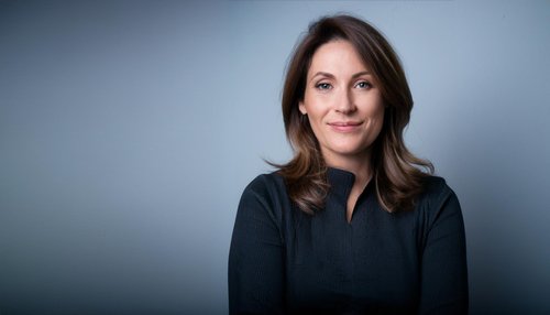 A woman smiling in a bright room