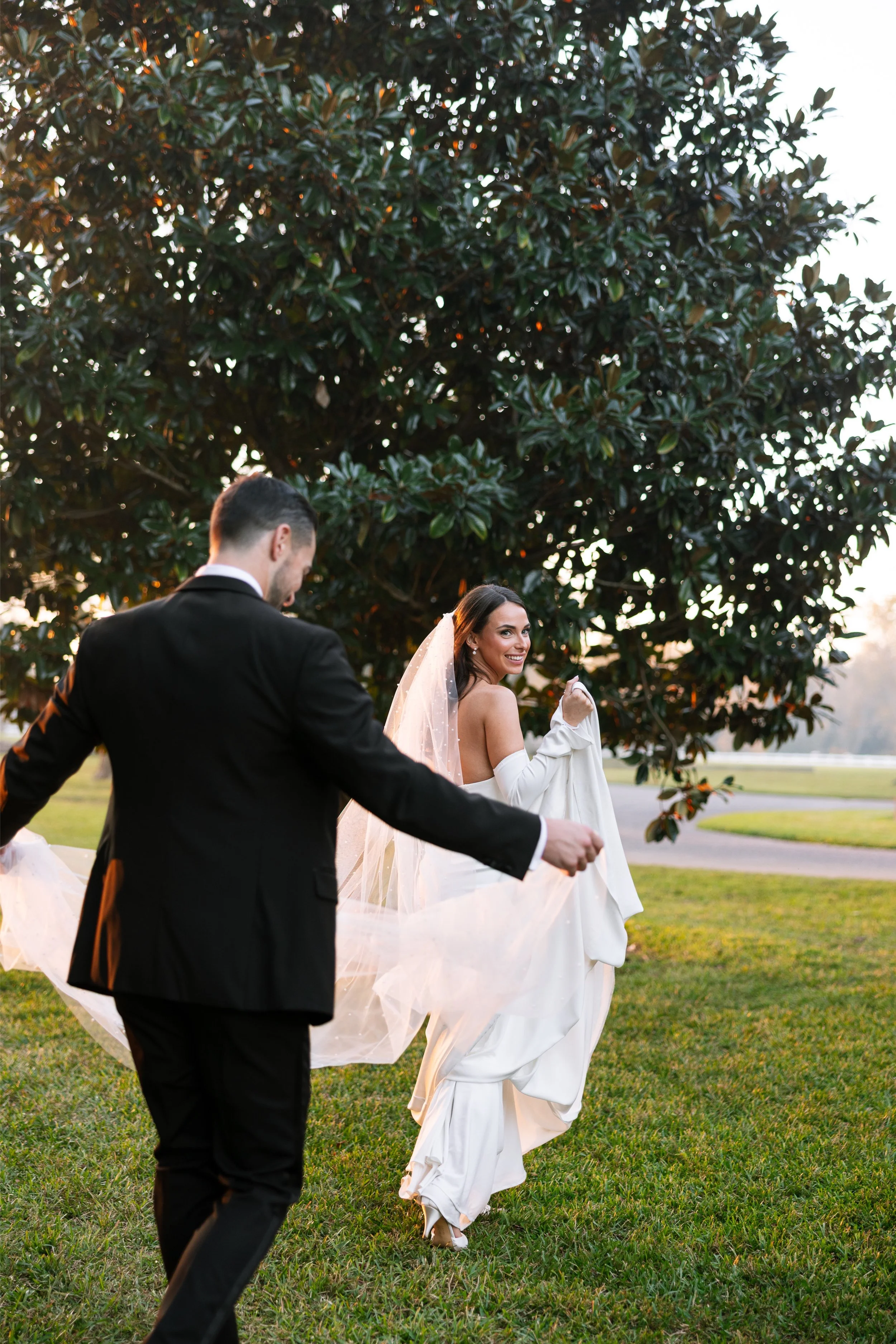 groom holding brides train as she smiles rosemary beach 30a wedding