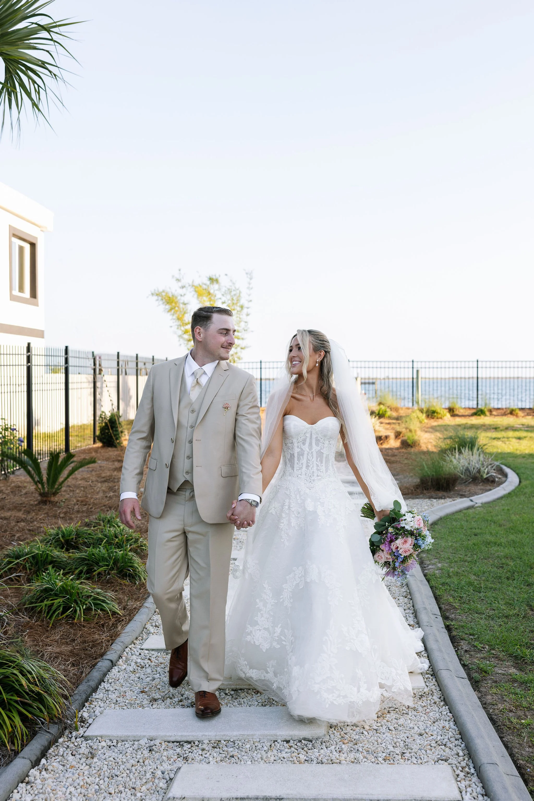 couple holding hands walking Bella villa pensacola wedding