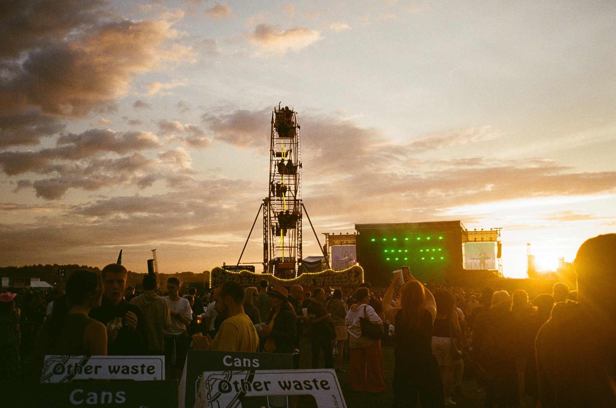 Sunset at outdoor festival  with crowd and stage.