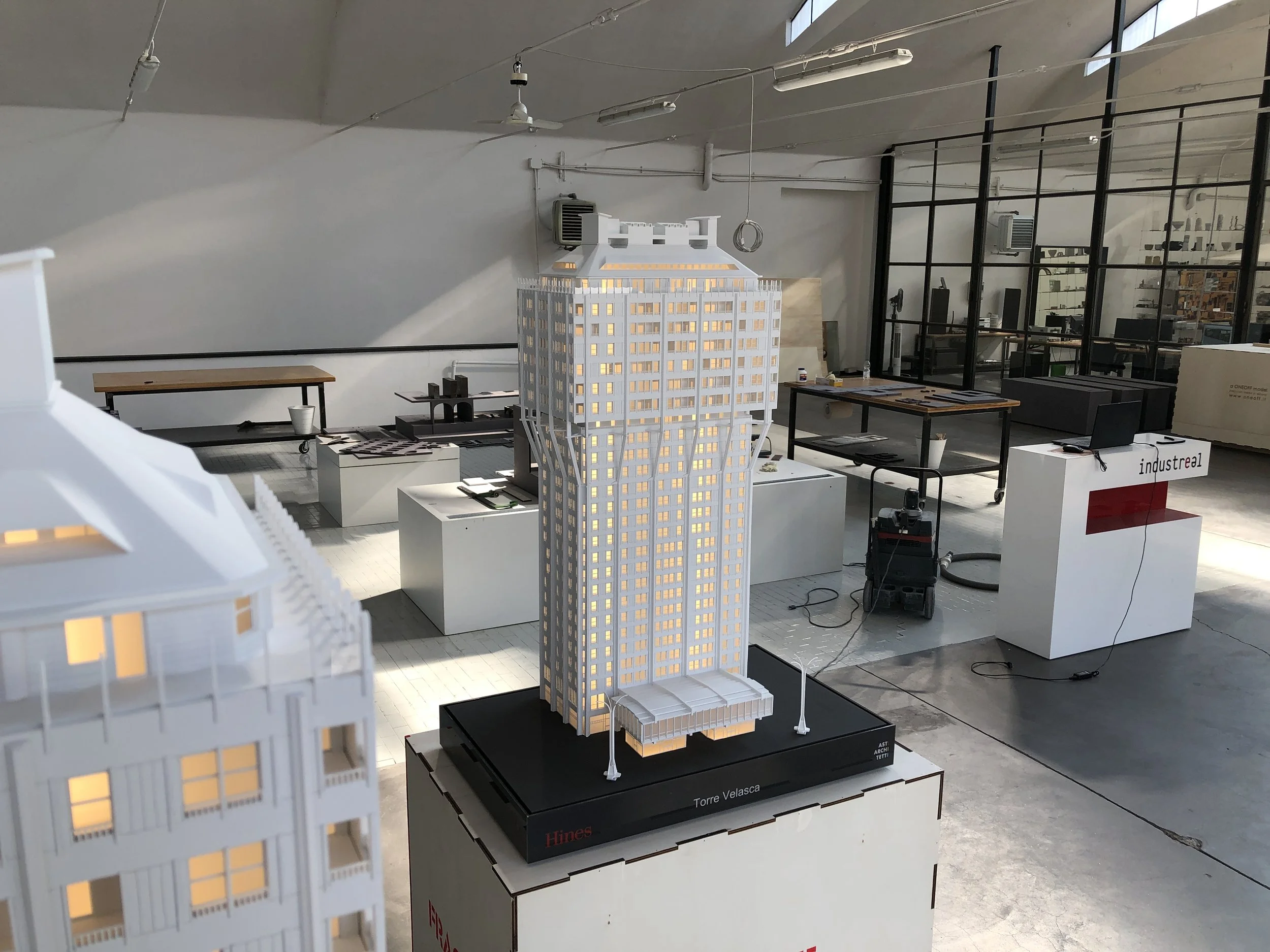 Modelli di un edificio in scala, con illuminazione interna, in un ambiente di design o di mostra.