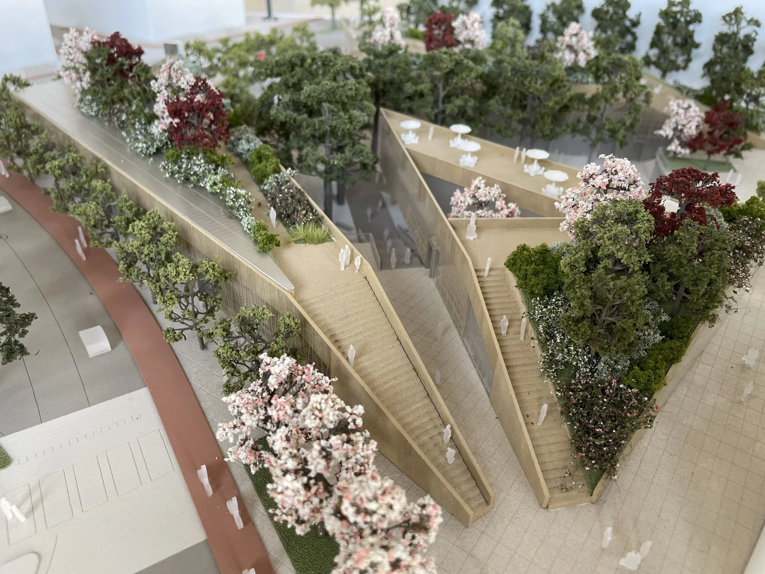 Modello di un progetto di giardino con alberi, siepi, fiori e strutture per rilassarsi, visualizzato dall'alto.