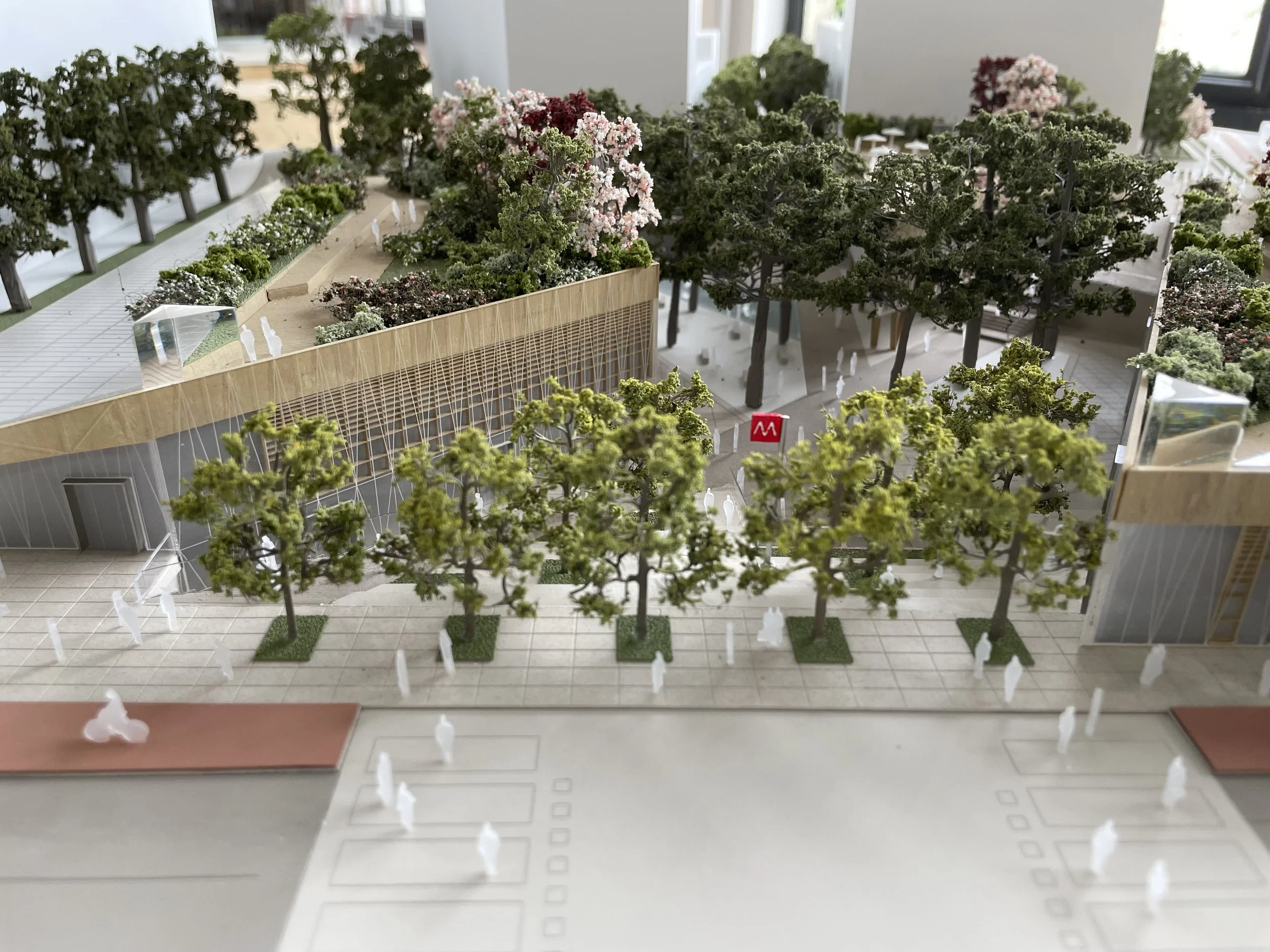 Modello in scala di un complesso edilizio con alberi e spazi verdi, parte di un progetto di urbanistica o architettura.