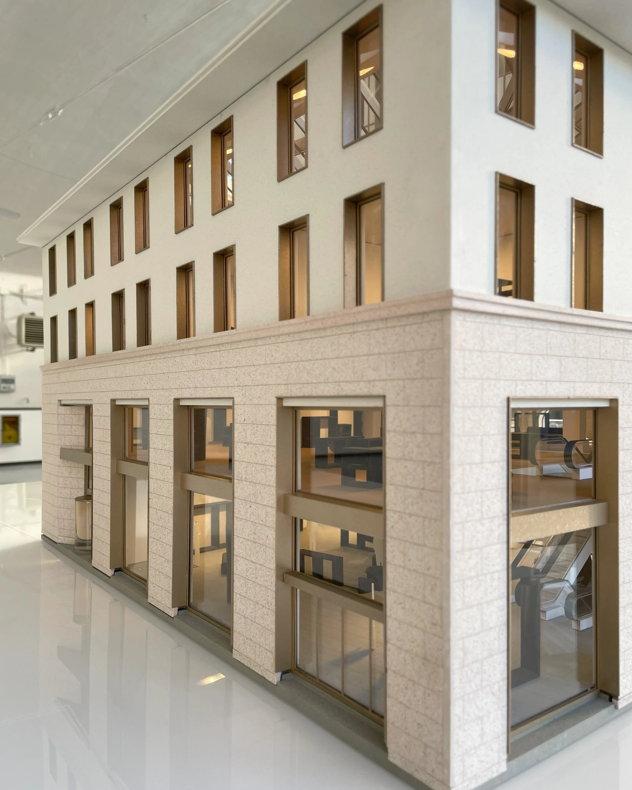 Modello di un edificio moderno con pareti in pietra e molte finestre.