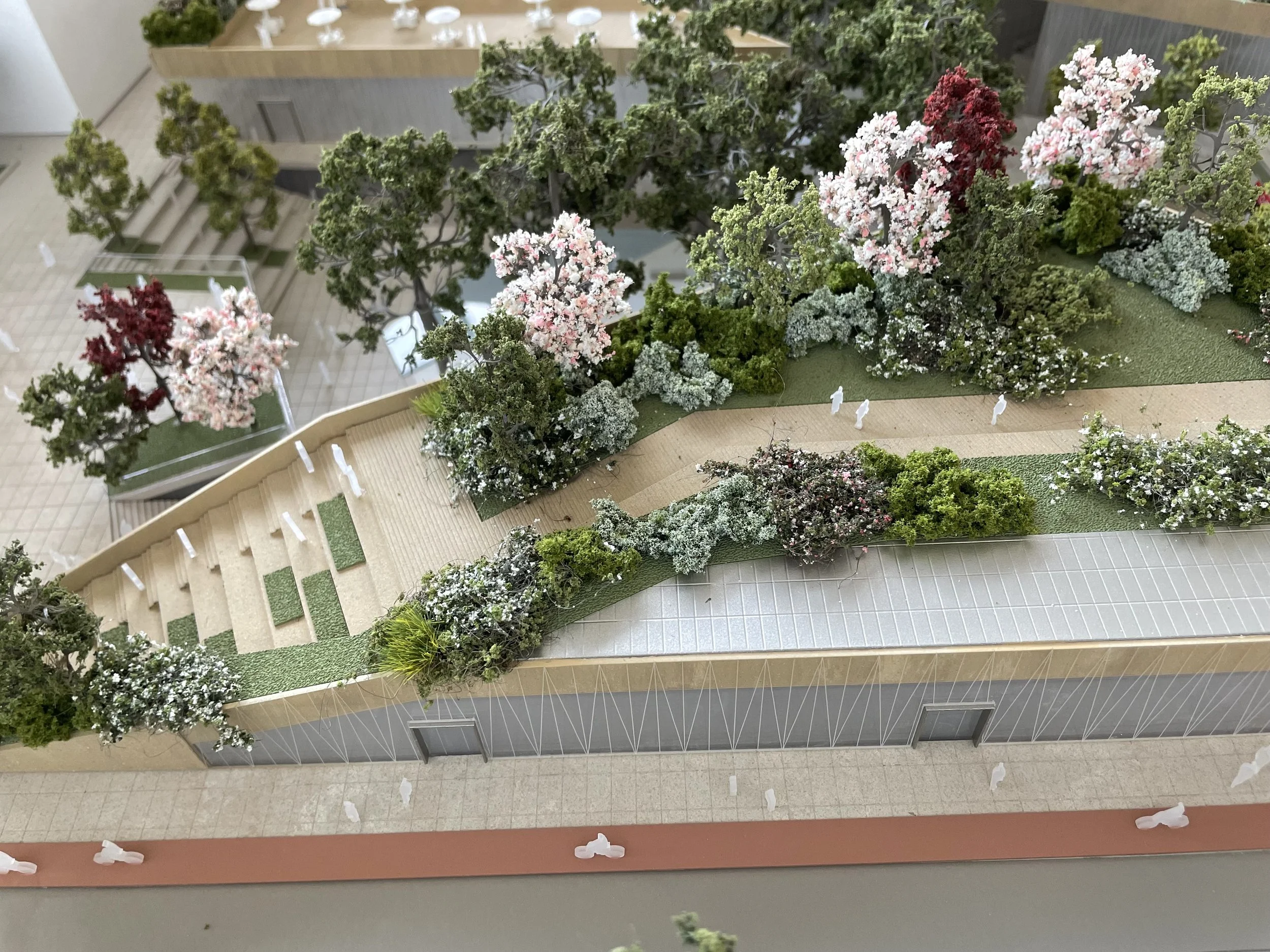 Un modello in scala di un edificio con molte piante in aria e alberi artificiali situati lungo una terrazza.