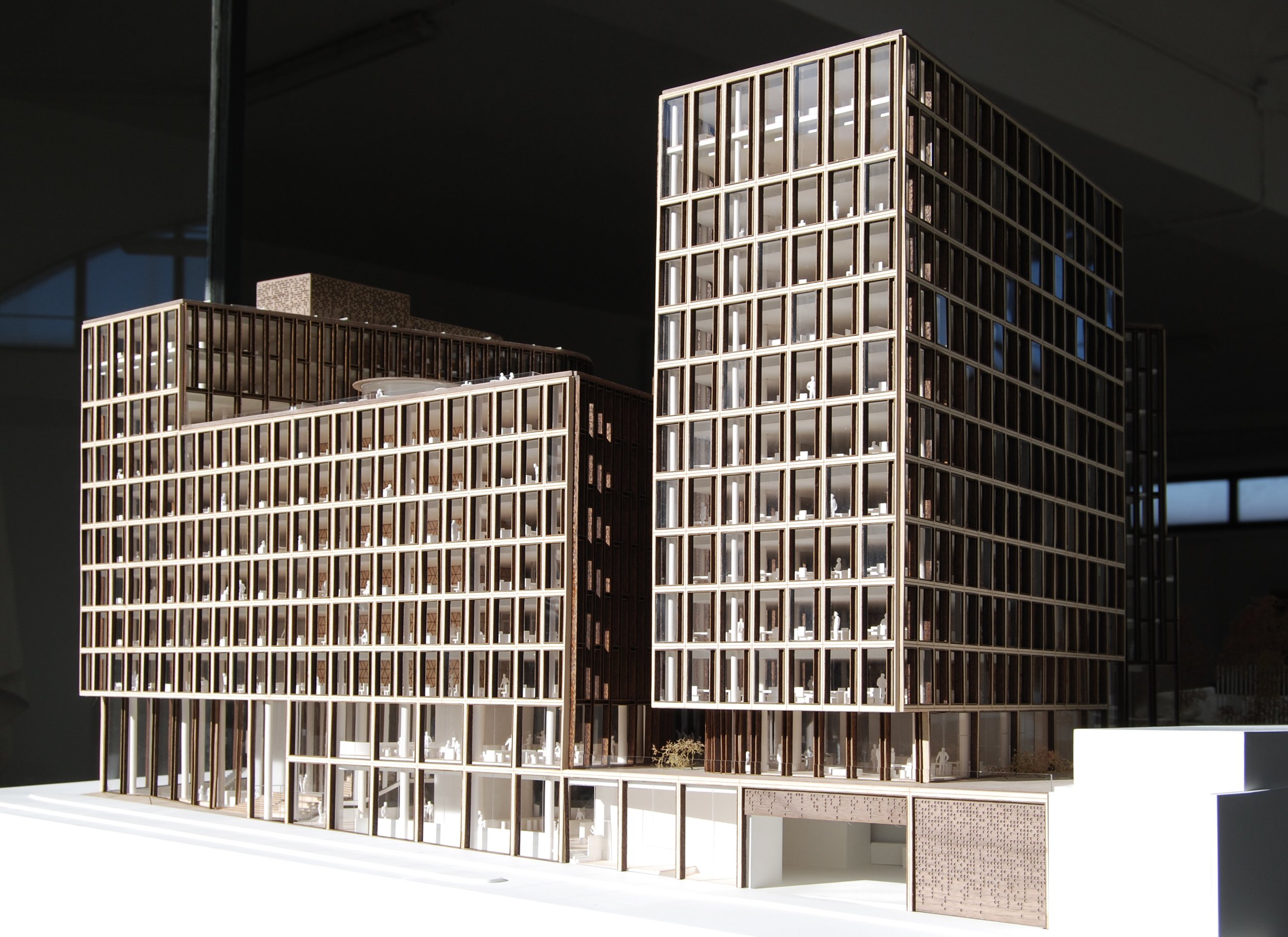 Modello architettonico di un moderno complesso edilizio con edifici in legno e grandi vetrate.