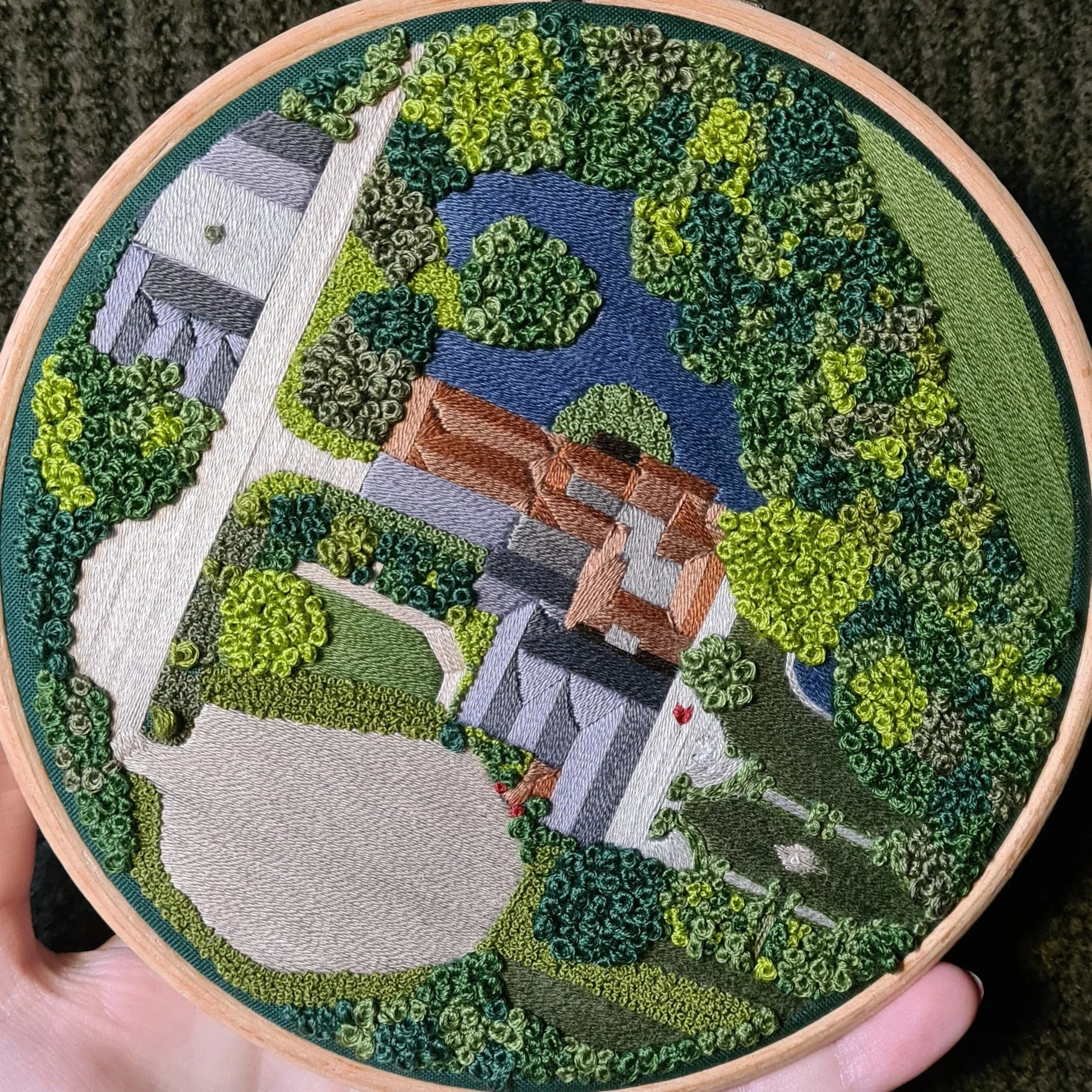 Aerial landscape embroidery of a stately home, trees, and a lake
