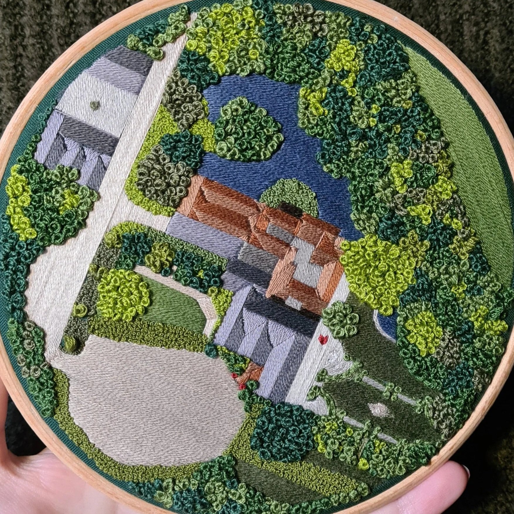 Aerial landscape embroidery of a stately home, trees, and a lake