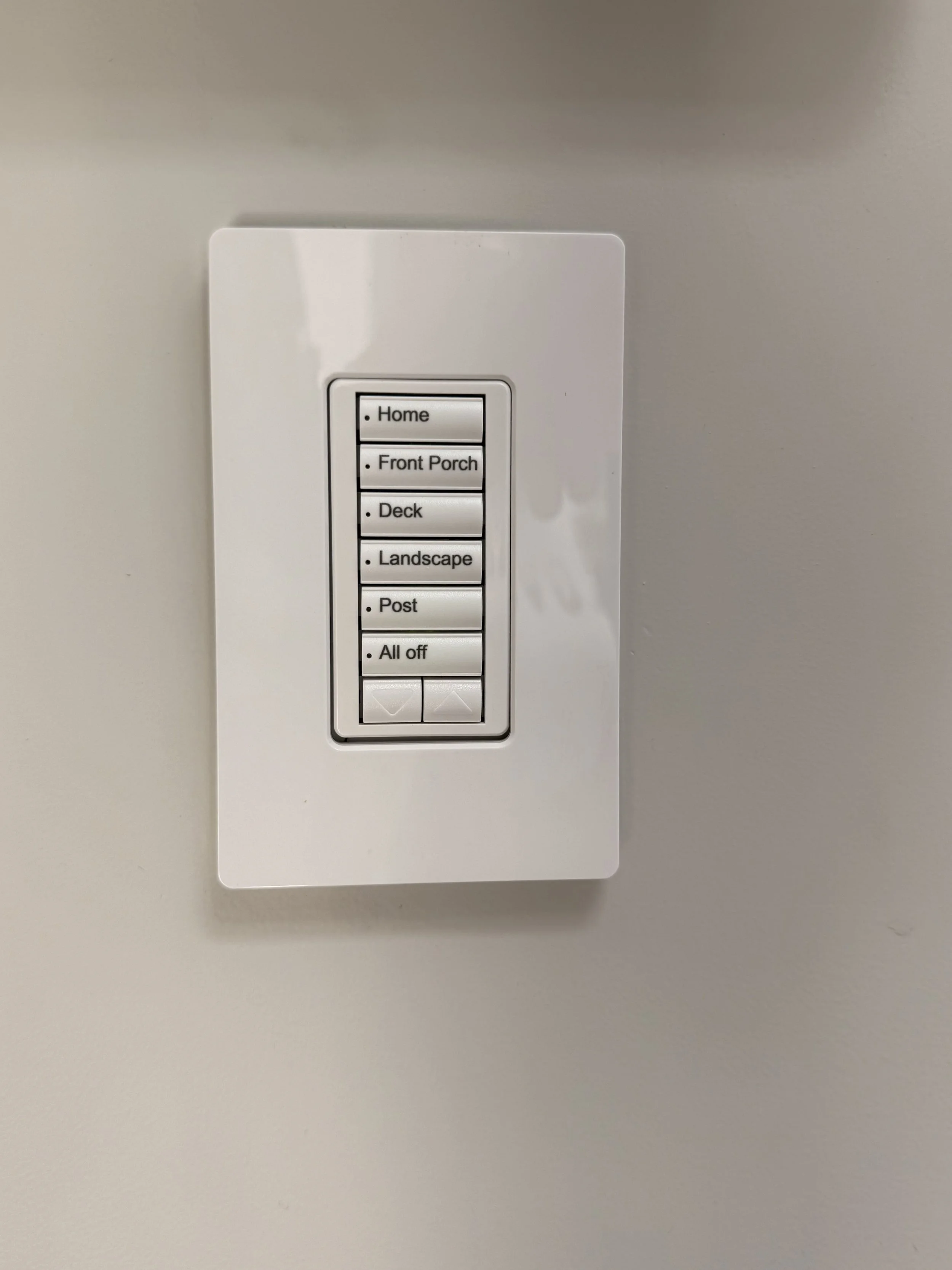 Lutron Wall-mounted switch with labeled buttons for controlling outdoor lighting options: Home, Front Porch, Deck, Landscape, Post, All Off.