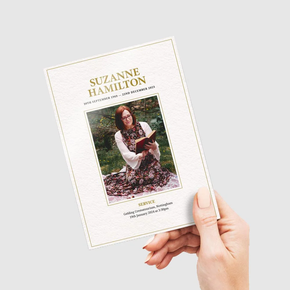 Funeral program for Suzanne Hamilton with a photo of her reading a book outdoors on the cover.