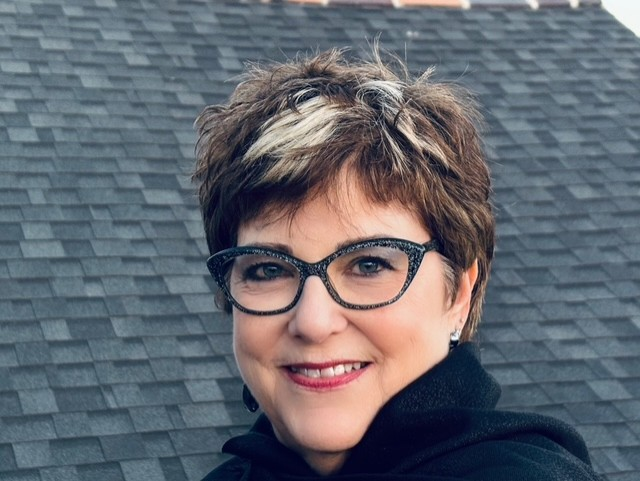 White female with glasses and short brown hair with blonde highlights
