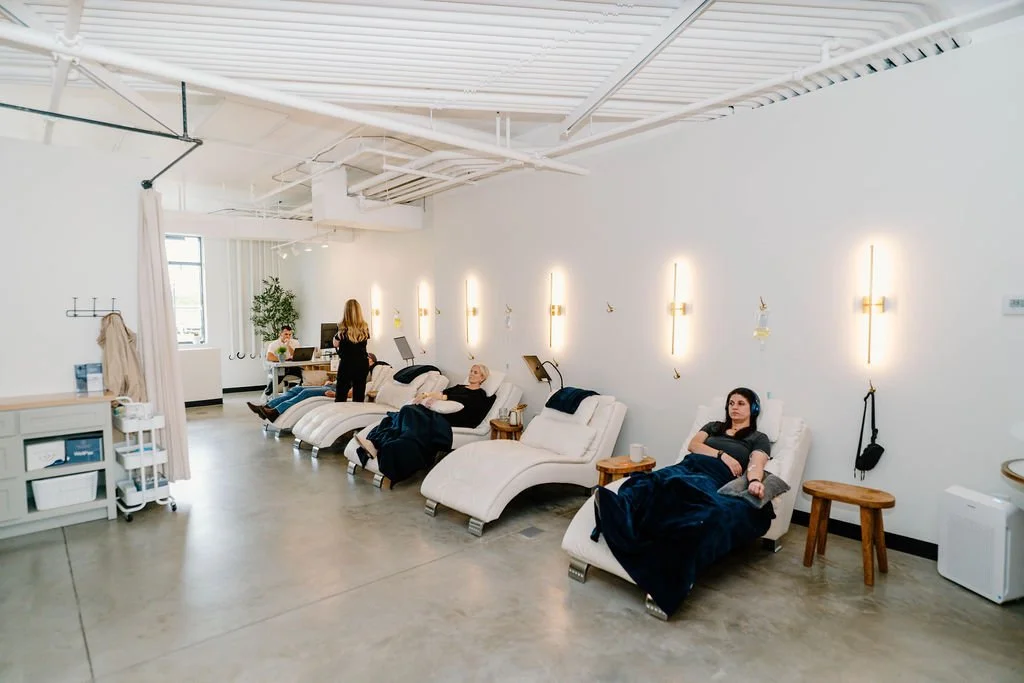 People relaxing on lounge chairs in a modern, minimalistic beauty or wellness clinic