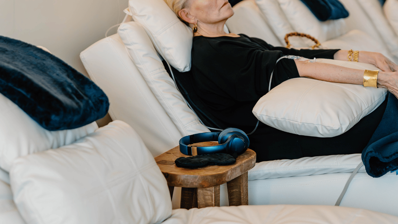 woman with IV drip and headphones on a side table