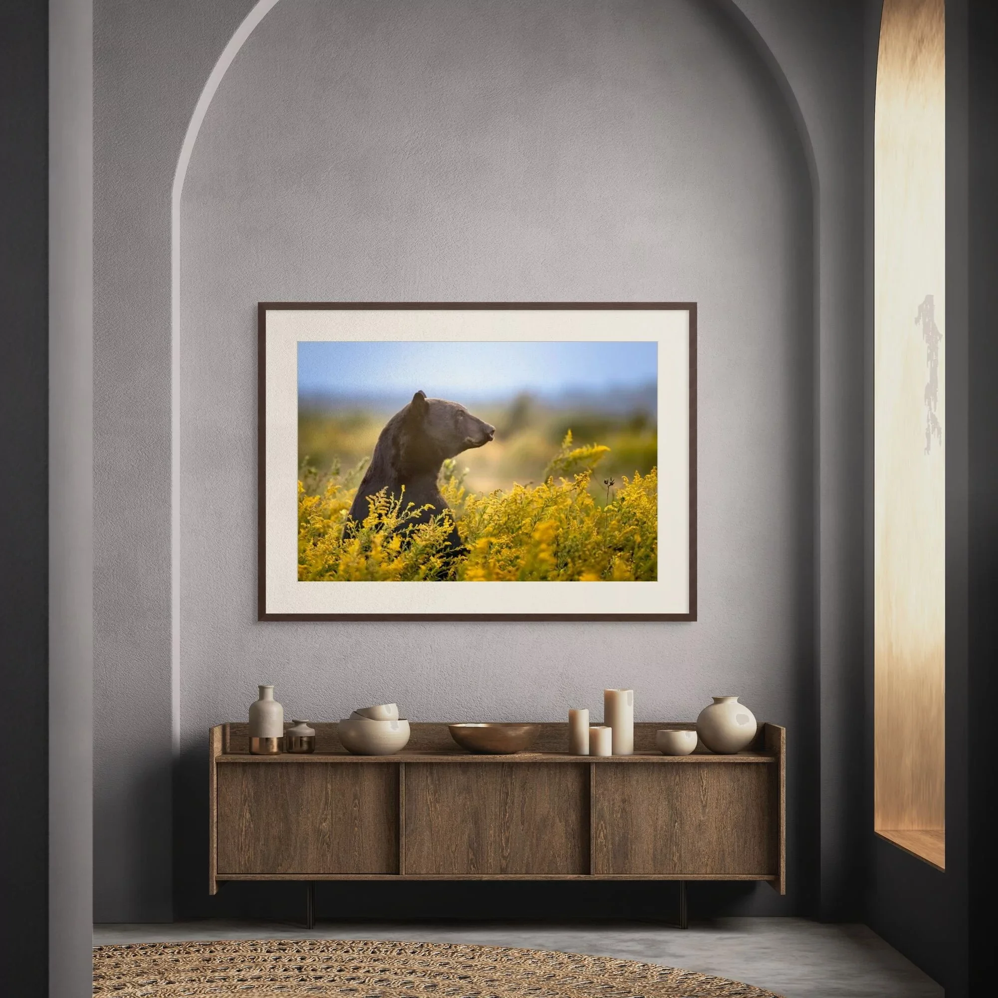 a fine art print of a black bear in golden rod hanging in a luxury room.