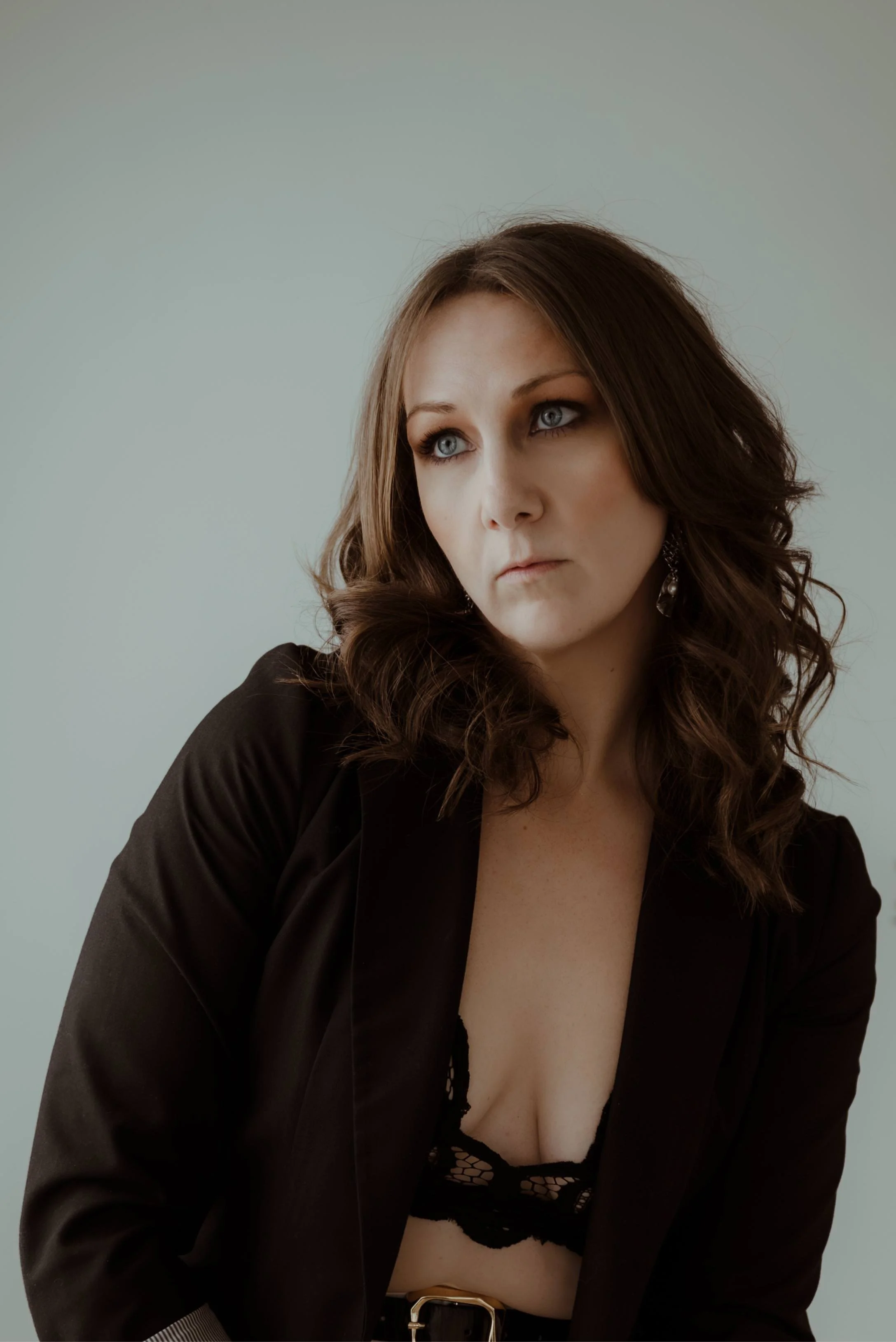 Portrait of Canadian dark fantasy romance author Kaitlyn L. Hill in a white studio, a moody yet professional and minimal aesthetic.